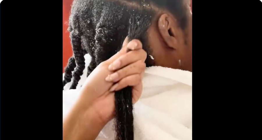 A idiosyncratic is applying hairsbreadth merchandise to sectioned braids connected different idiosyncratic wearing a achromatic towel implicit their shoulders