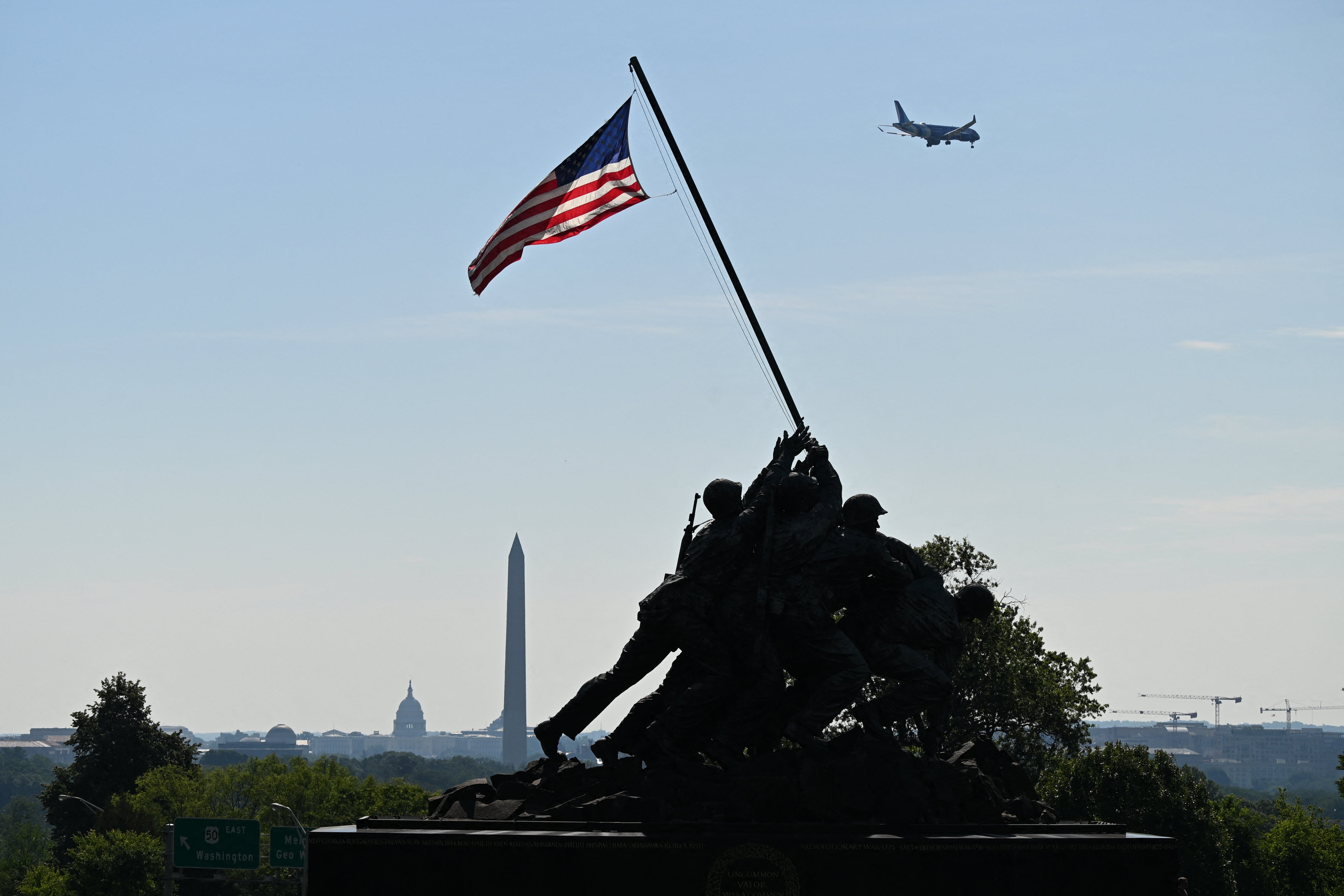 Silhouette of Iwo Jima Memorial with U.S. flag, Washington Monument, Capitol dome, and level   successful  entity  successful  background