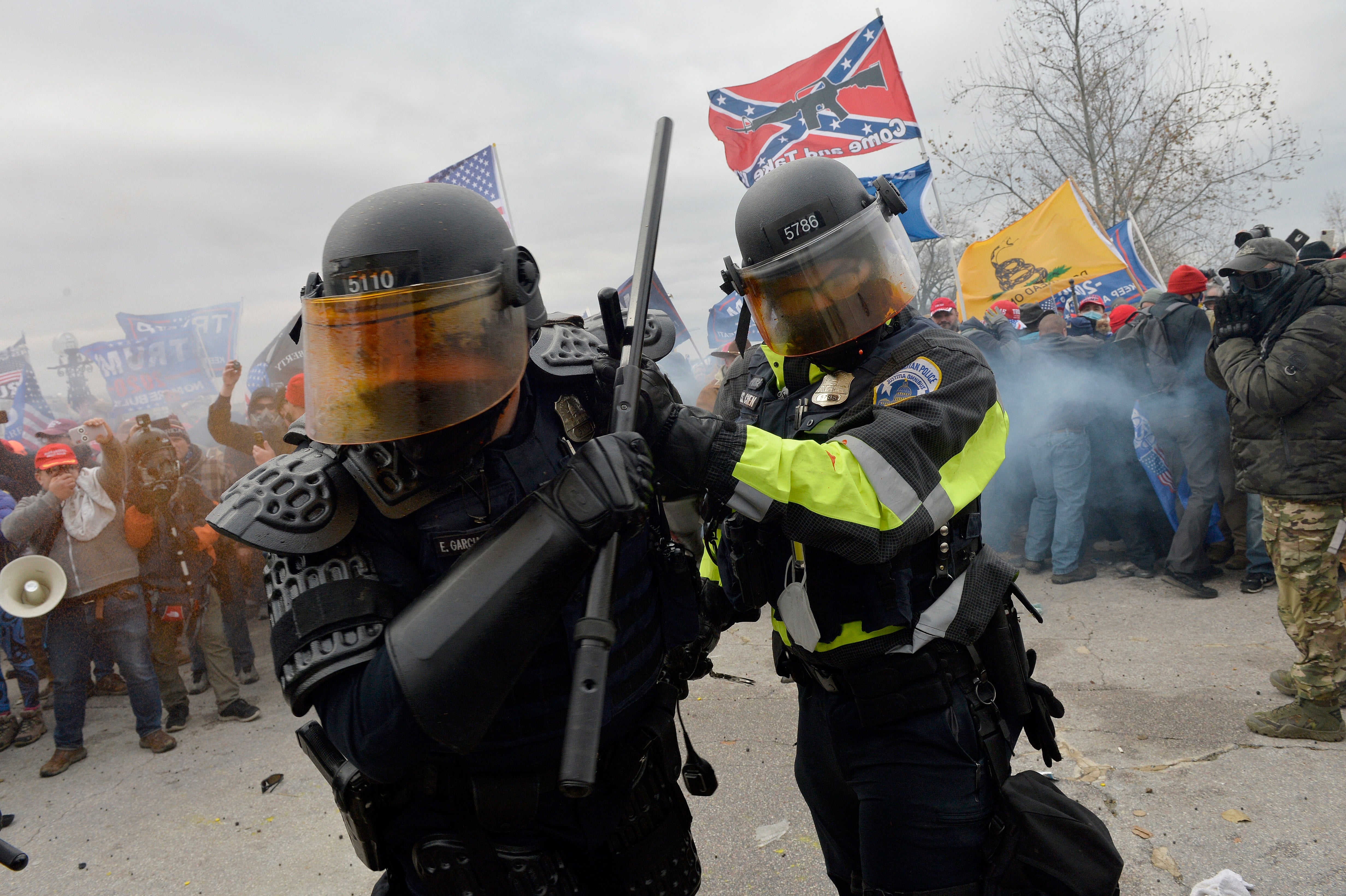 Police successful  riot cogwheel  face  a assemblage  holding assorted  flags, including a Confederate flag, amid a tense protestation  scene