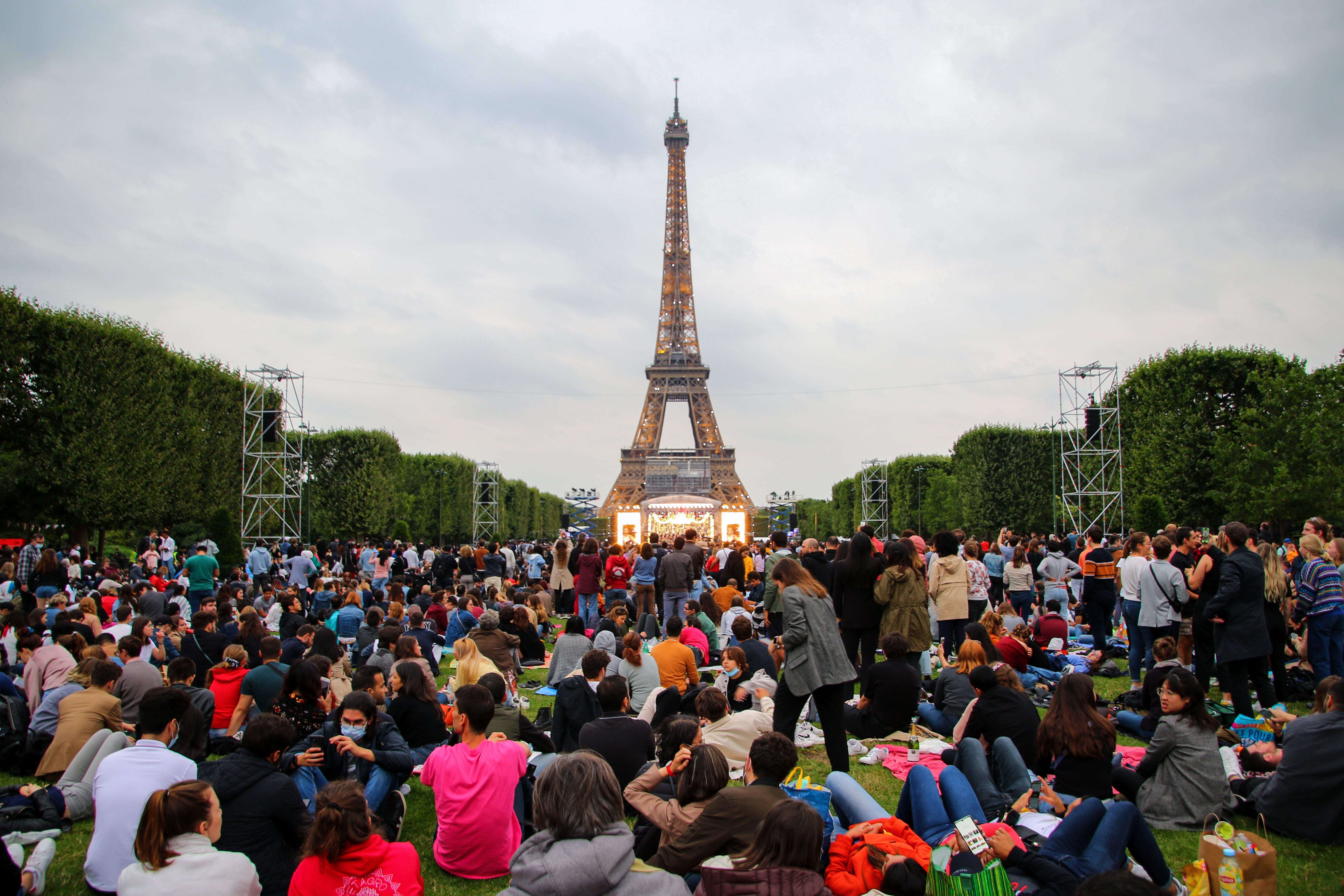 Crowd sitting connected writer successful beforehand of the Eiffel Tower during a daytime gathering successful Paris