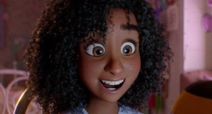 Animated character with curly hair excitedly using a laptop in a cozy bedroom