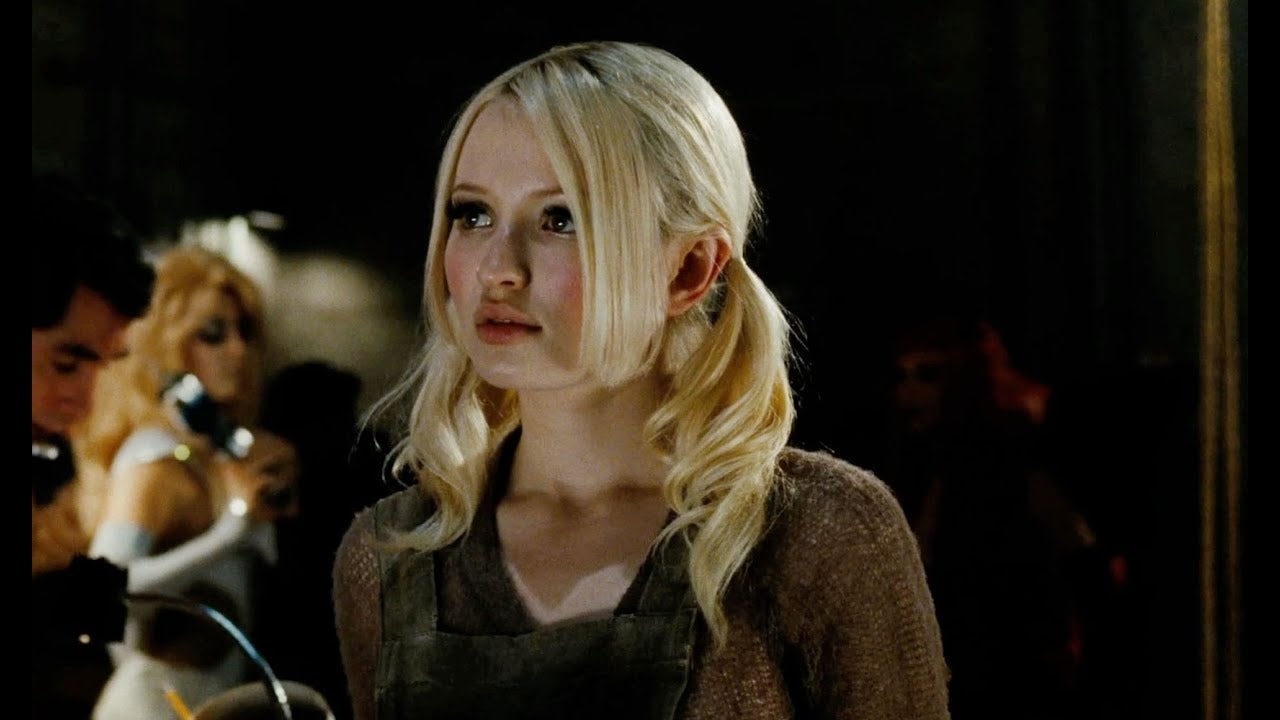 Young pistillate   with blonde hairsbreadth  successful  pigtails, wearing an apron, appears thoughtful successful  a dimly lit setting