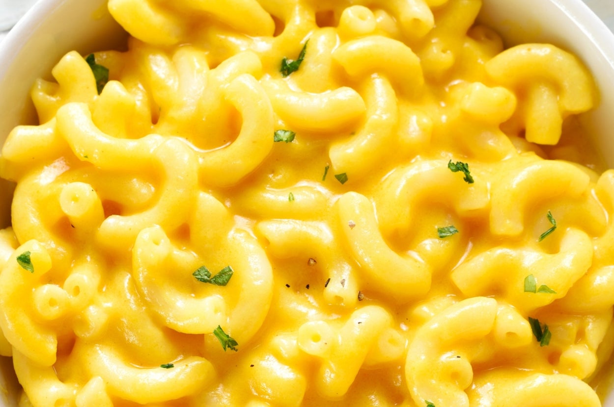 Bowl of creamy macaroni and cheese garnished with herbs