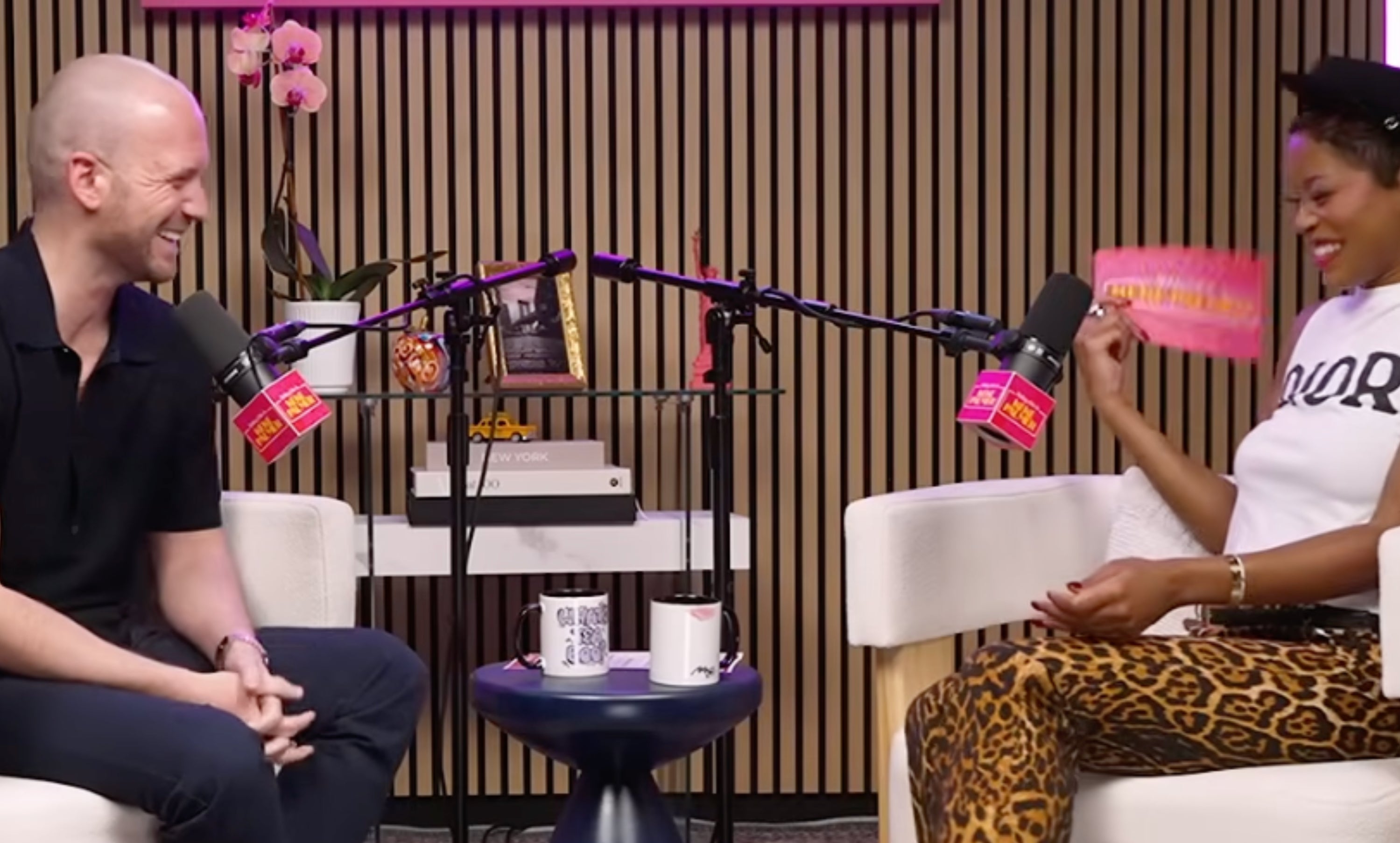 Two radical beryllium successful a podcast workplace with a neon motion speechmaking "Baby, this is Keke Palmer." One wears a achromatic shirt, the different a vessel apical and leopard people pants