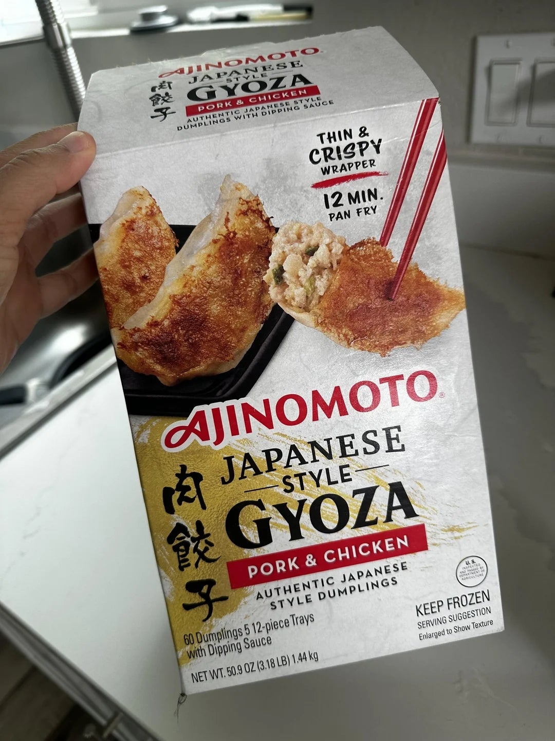 A container  of Ajinomoto Japanese Style Pork &amp;amp; Chicken Gyoza, highlighting bladed  and crispy wrappers and a 12-minute pan-fry time