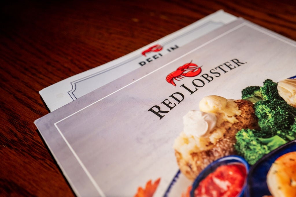 Red Lobster-meny på et trebord, med et bilde av en sjømatrett med brokkoli og dipsauser