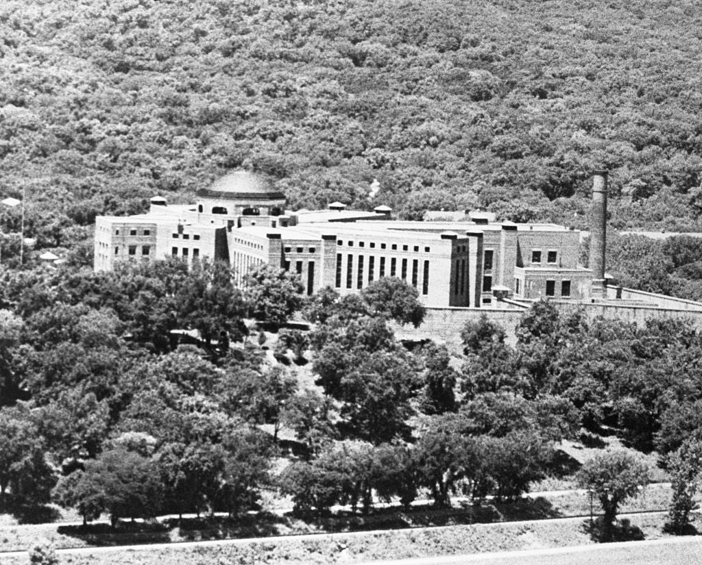 A large, historical  gathering  surrounded by trees, situated successful  a wooded landscape