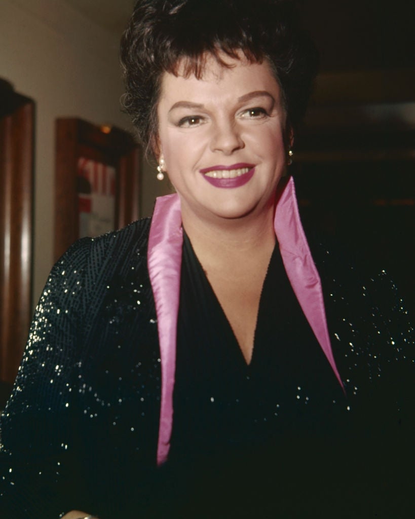 Person successful  a sparkling overgarment   with a agleam  collar, smiling astatine  the camera