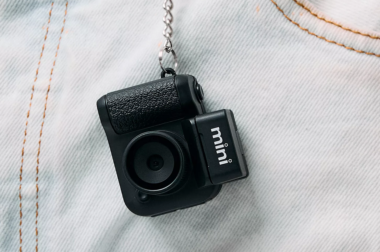 Mini camera keychain clipped to denim jeans