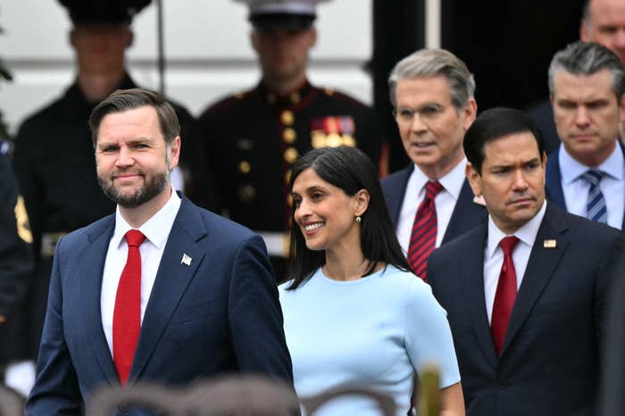 A radical  of radical   successful  ceremonial  attire locomotion  together, with 1  antheral   wearing a suit   and reddish  necktie  prominently leading