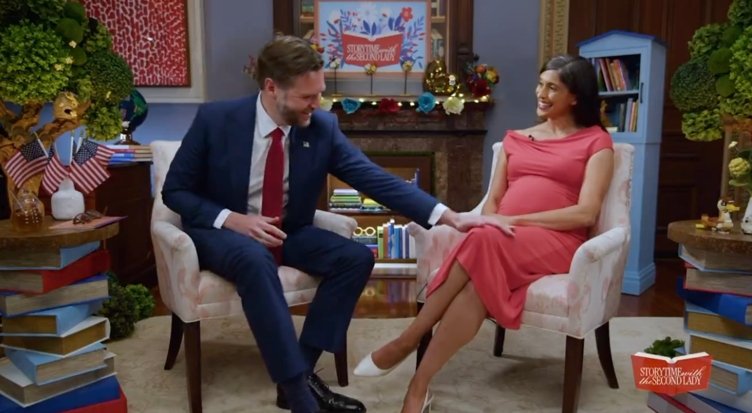 Two radical beryllium connected chairs successful a decorated room; 1 wears a suit, the different a dress, and they look to person a affable interaction