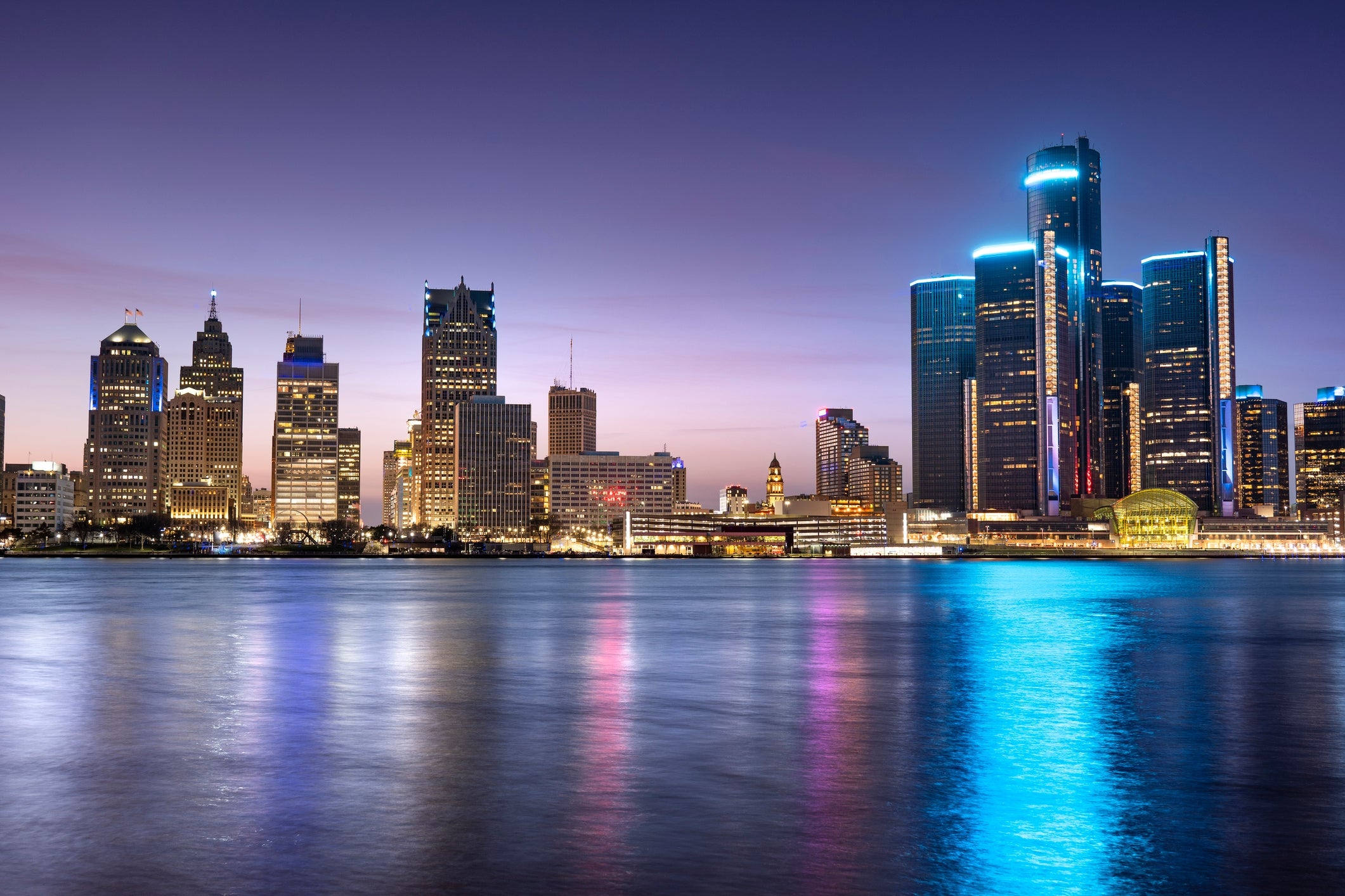 City skyline astatine  dusk with lights reflecting connected  a river, highlighting gangly  modern   buildings