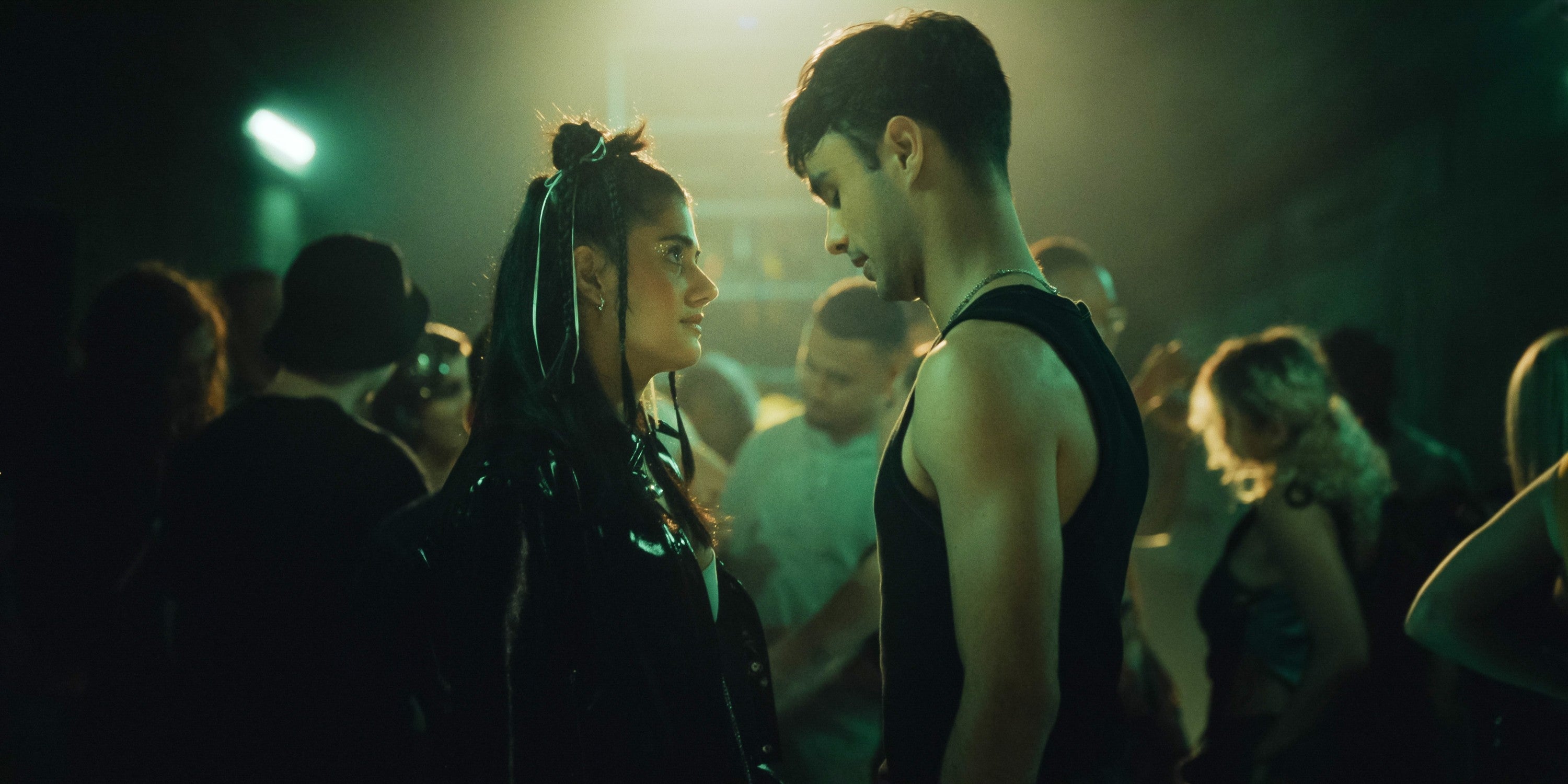 Two radical   look   each   different   intimately  successful  a dimly lit enactment      scene, surrounded by a crowd