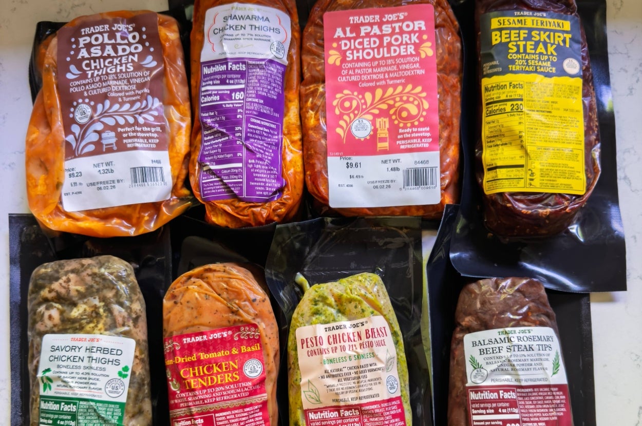 Various Trader Joe's marinated meat packages displayed, including chicken thighs, diced pork, and beef steak, with diverse seasoning labels
