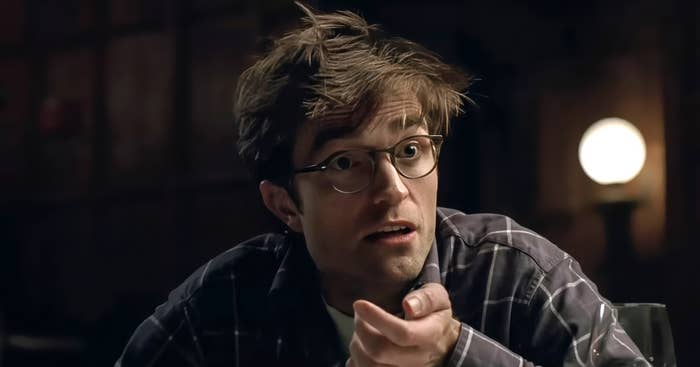 A idiosyncratic   with tousled hair, wearing glasses and a plaid shirt, appears amazed  oregon  acrophobic   indoors