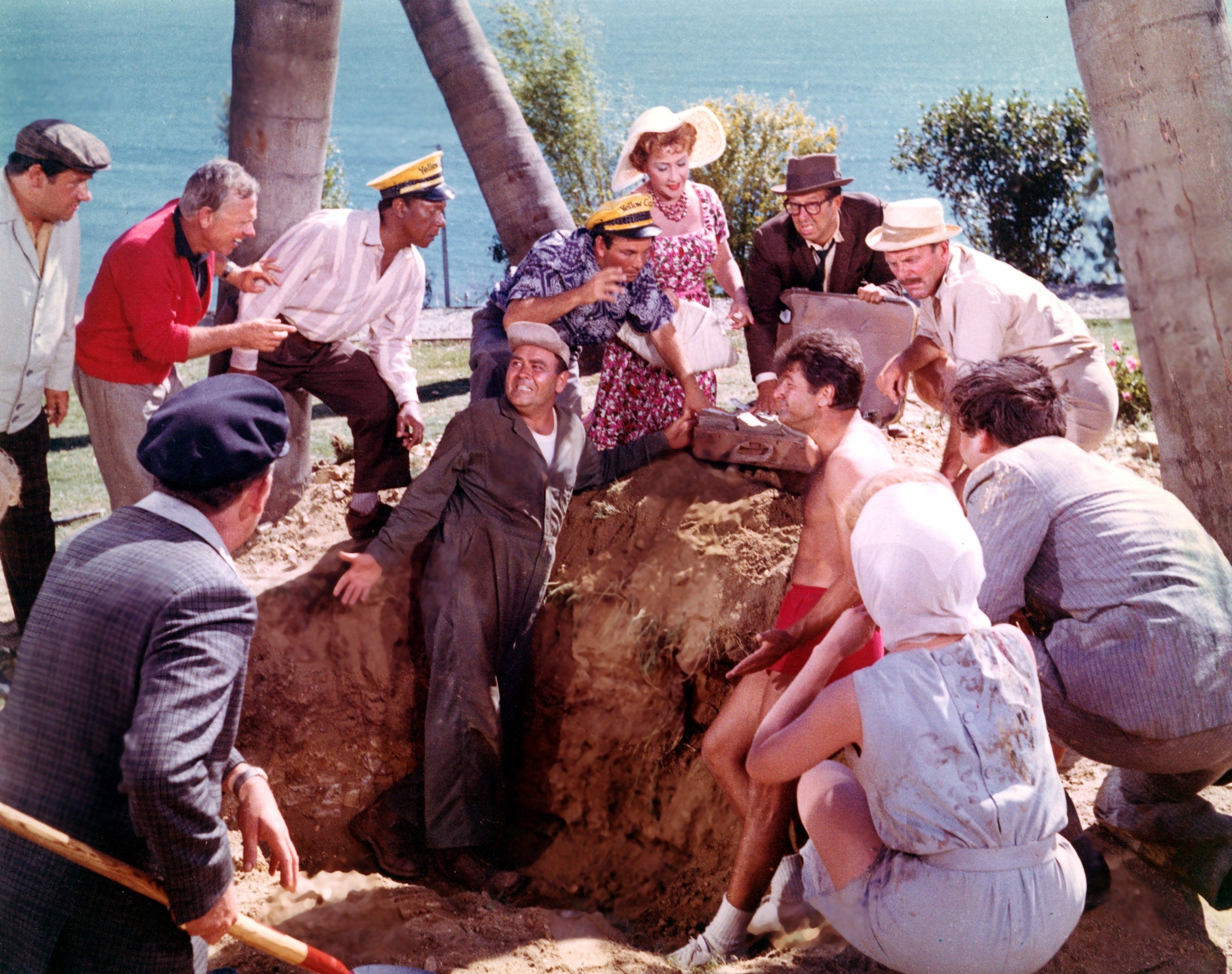 Group of radical   successful  vintage attire gathered astir   a partially buried idiosyncratic   connected  a beach. It's a melodramatic  country   suggesting a comedic oregon  adventurous movie   plot