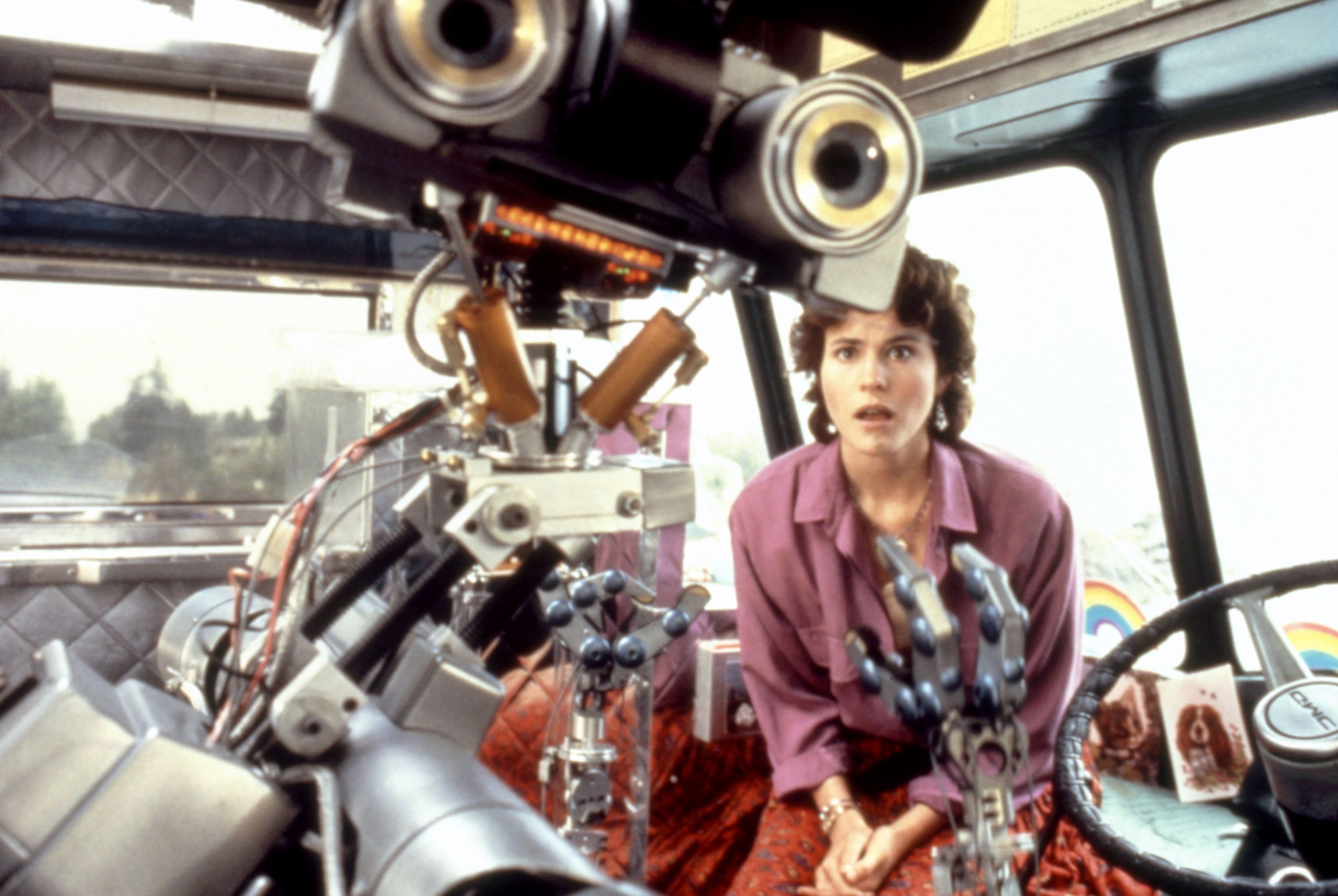 A idiosyncratic   looks amazed  portion    facing a large, analyzable  robot wrong  a vehicle, indicating a country   from a sci-fi movie  oregon  TV show