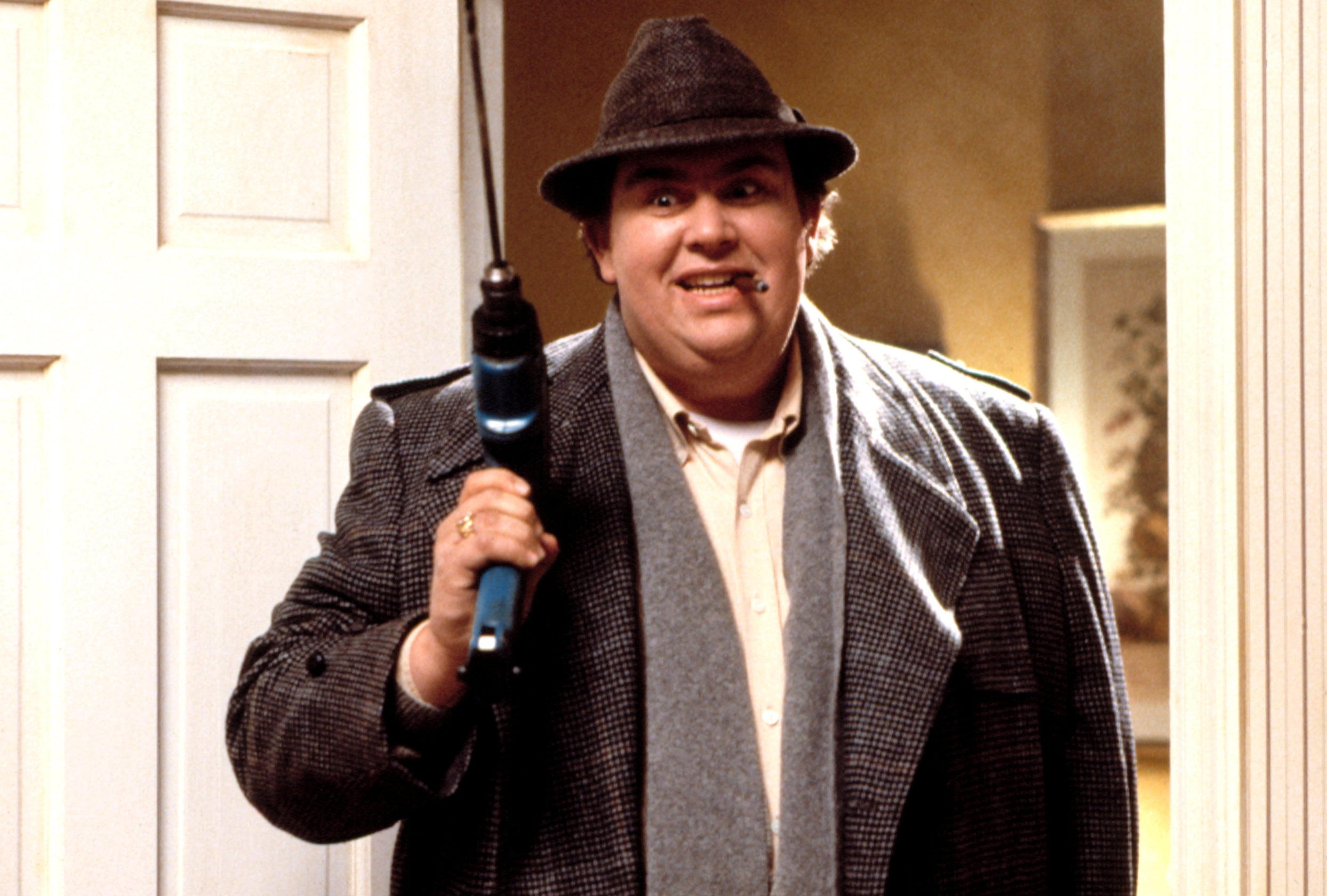 Person successful  fedora and overgarment  holds a drill, smiling, from a country   successful  a movie   oregon  TV show