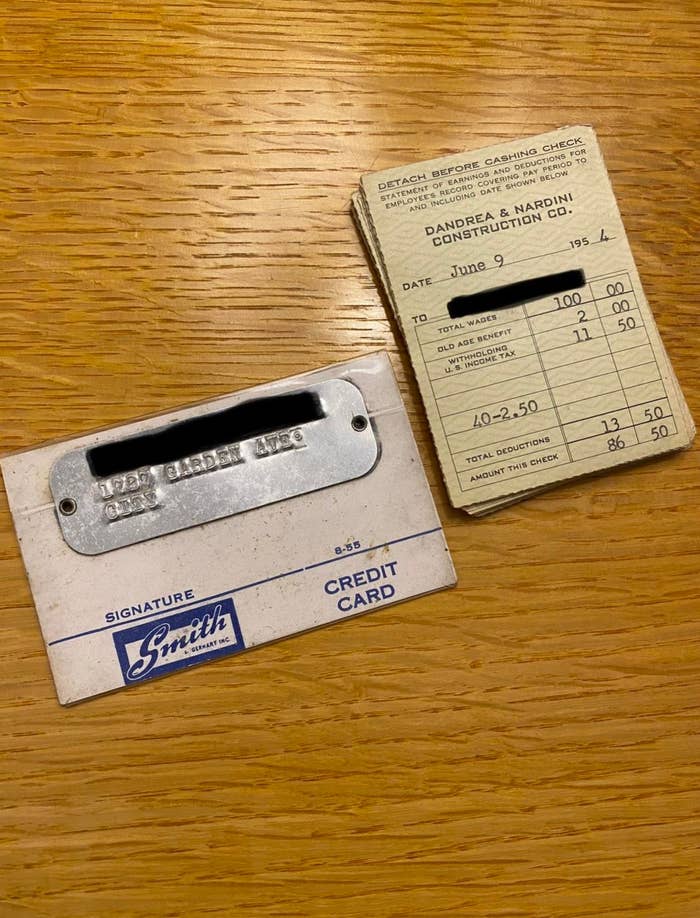 Vintage credit card with metallic plate and receipt from Andrea & Nardini Construction Co., dated June 9, 1954, on a wooden table