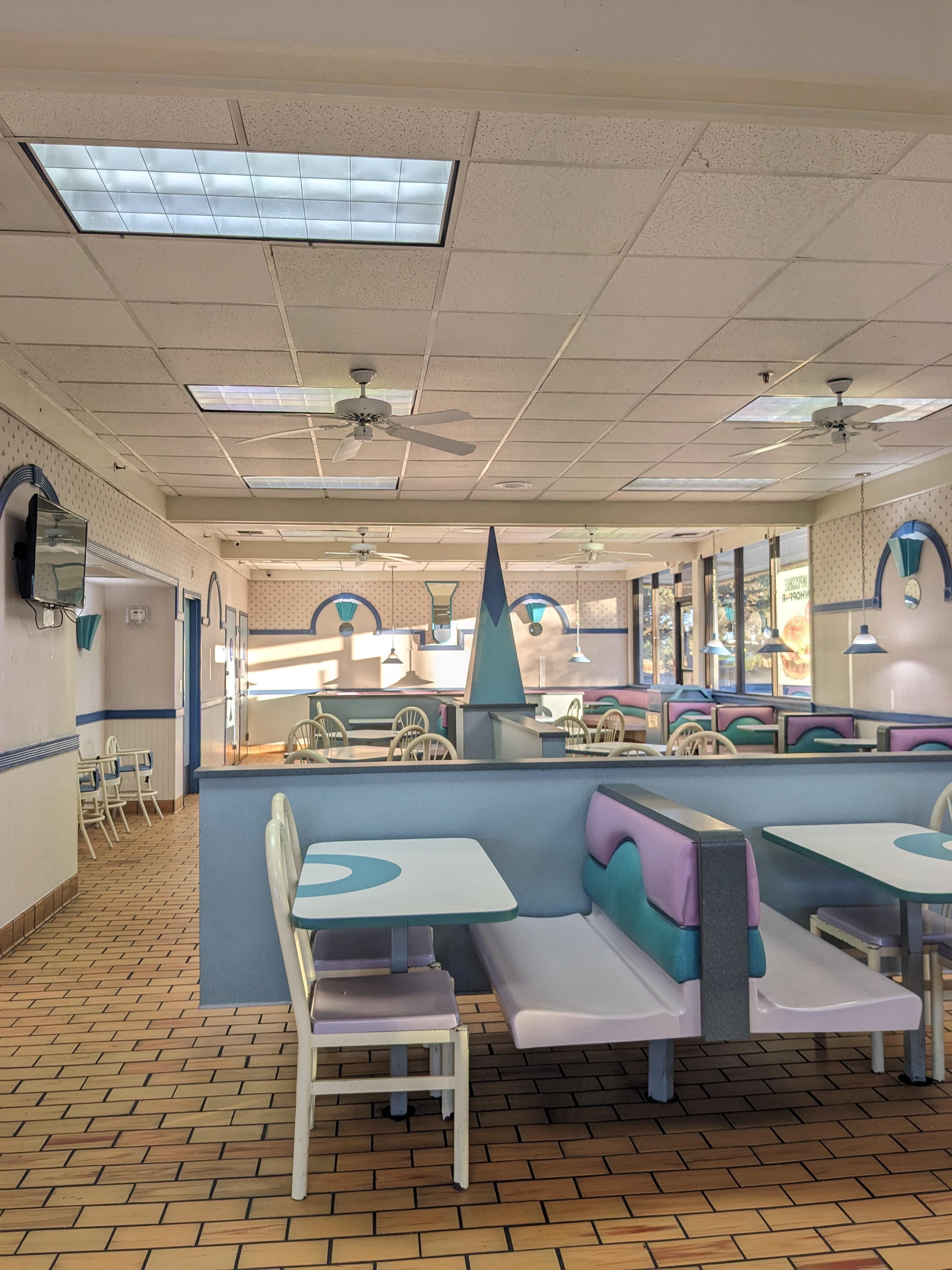 Empty fast-food restaurant interior with retro-style booths and decor