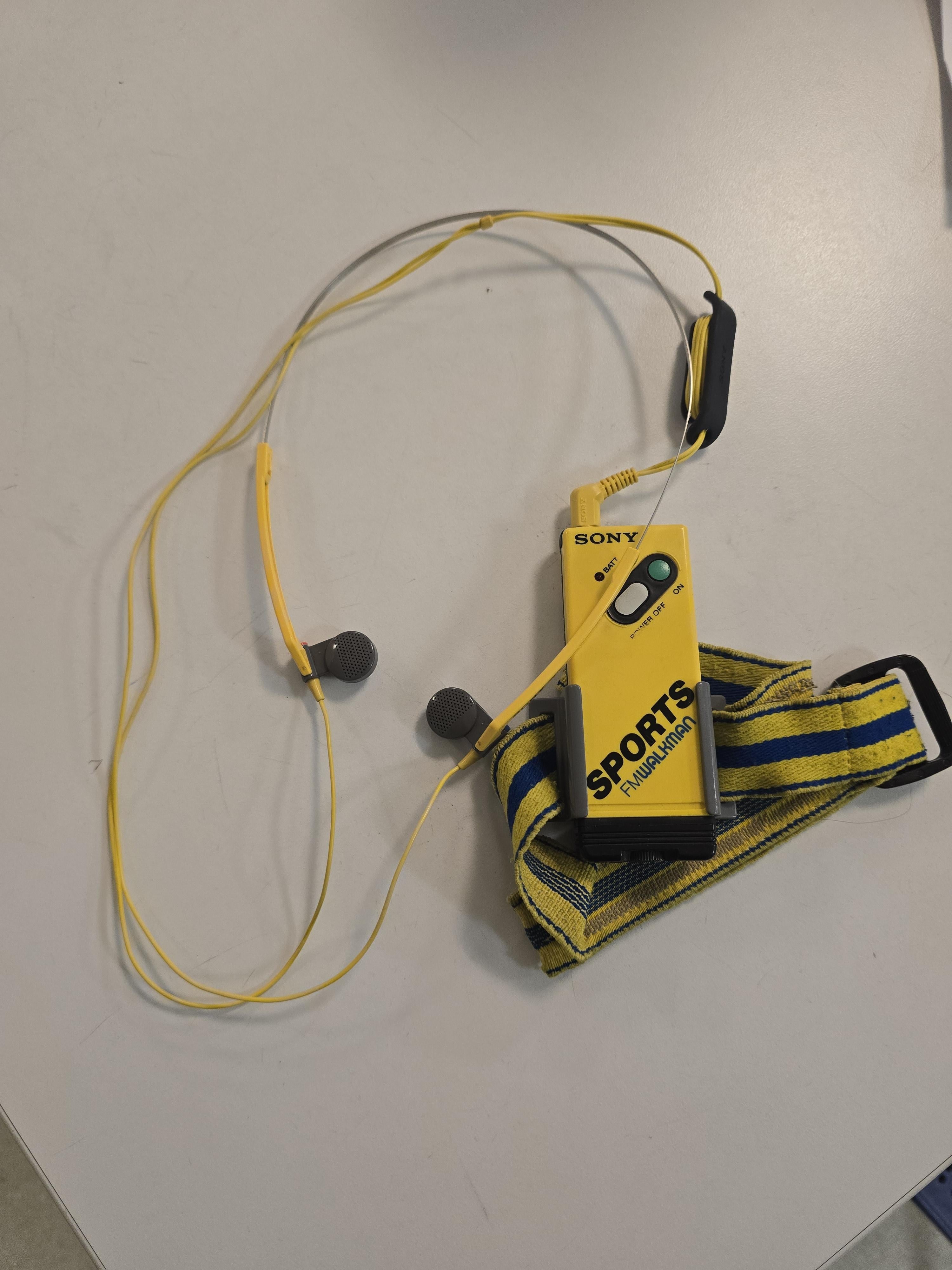 Sony Sports Walkman with wired earbuds and armband laid out on a table