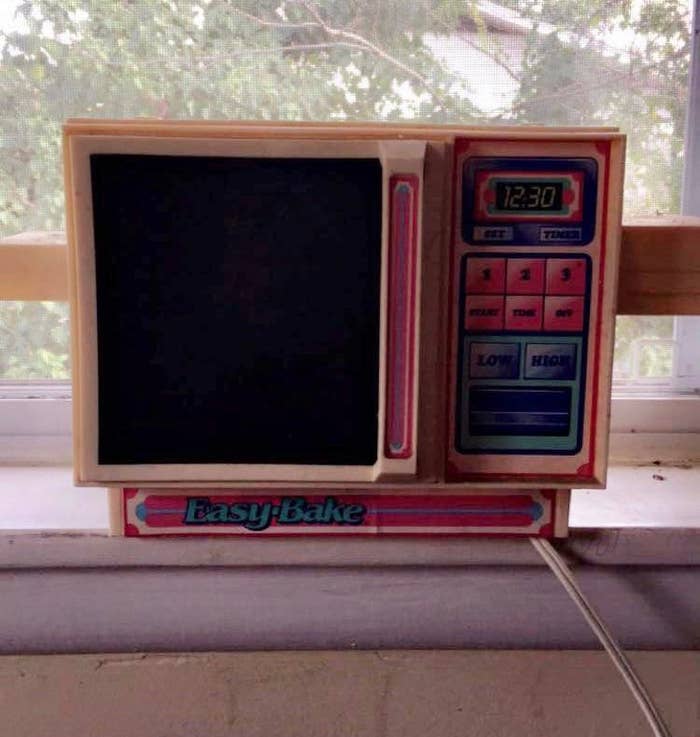 Easy-Bake Oven on a windowsill, with a timer and temperature dials on the right