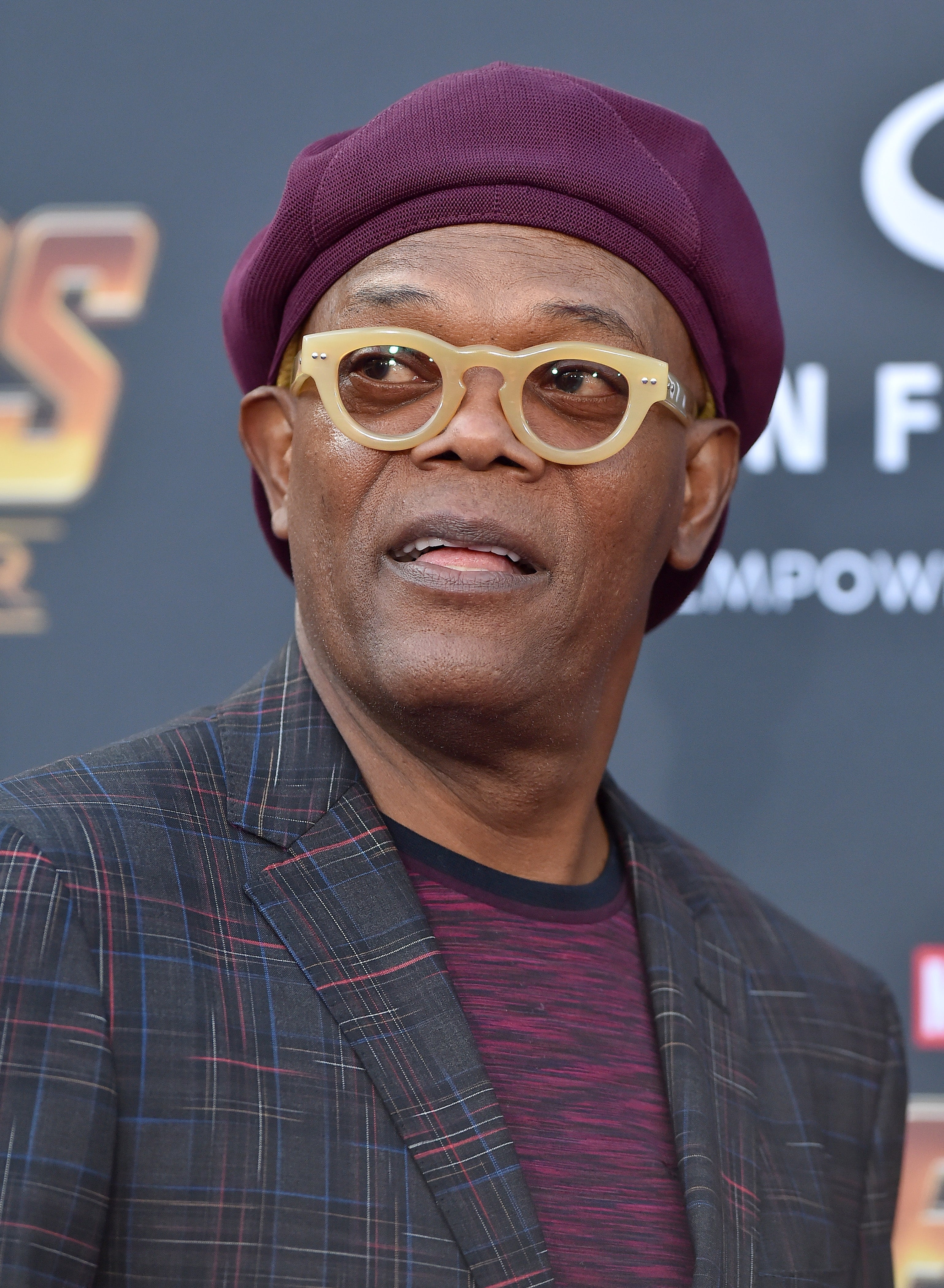 Samuel L Jackson in a plaid jacket and hat on the red carpet at a celebrity event