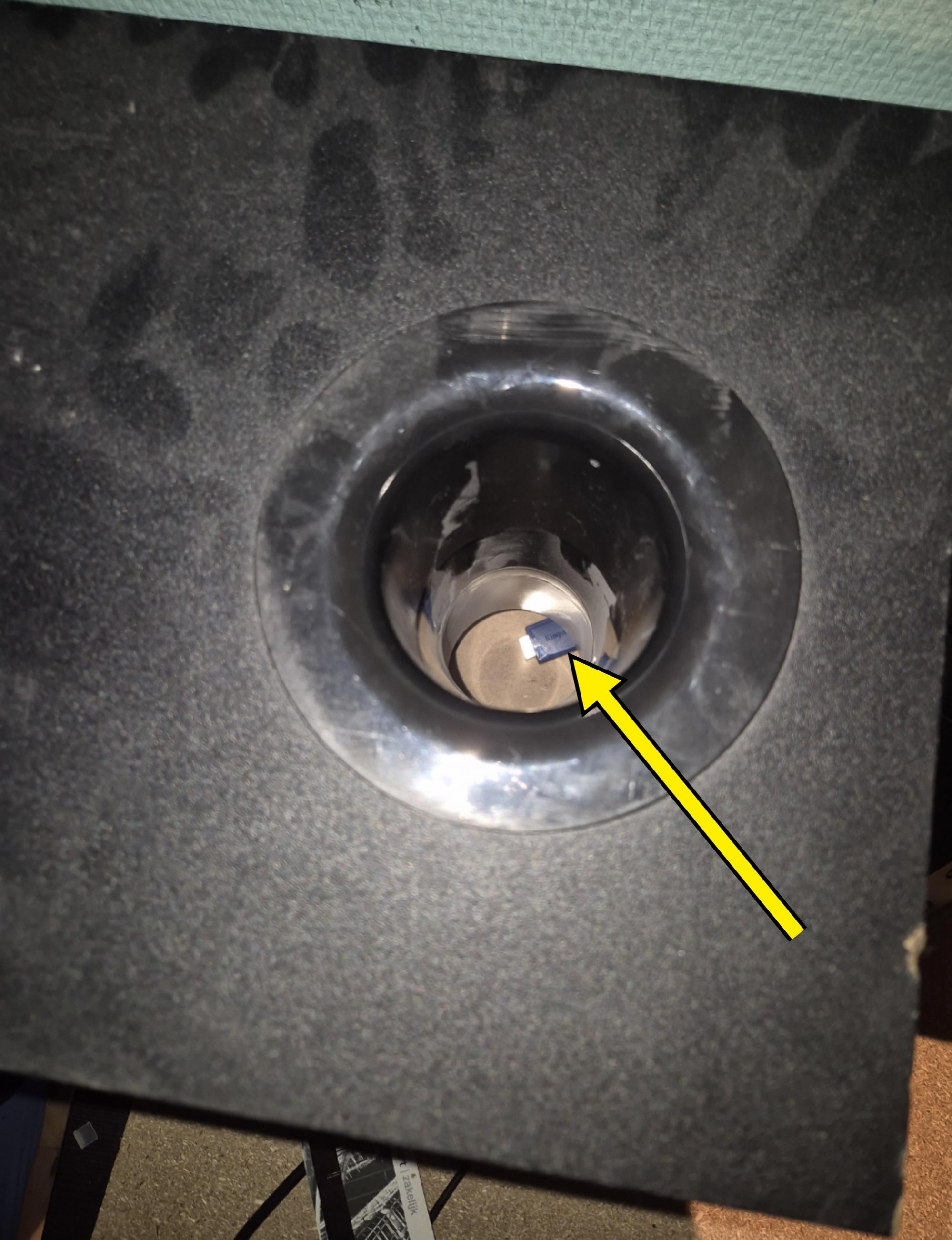 A close-up of a black cupholder with a light brown background