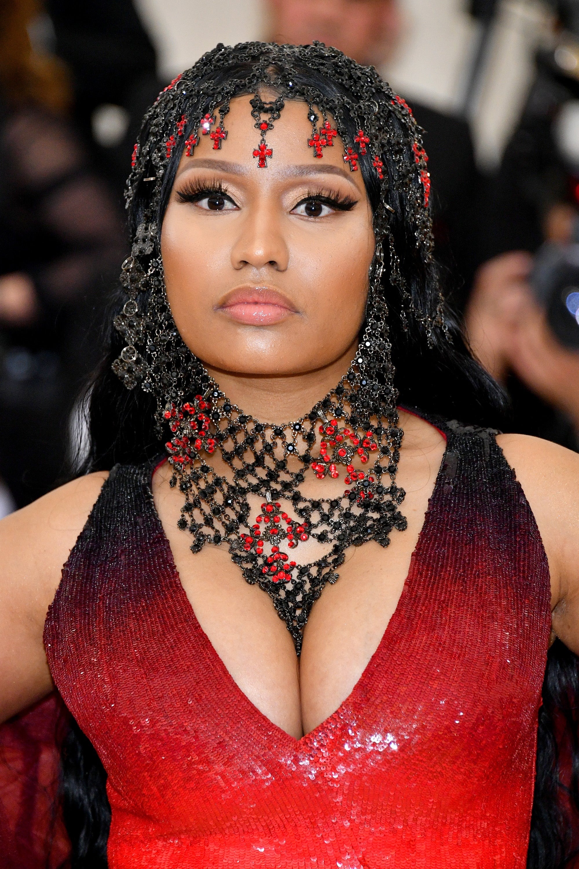 Nicki Minaj in ornate dress with beaded headpiece and necklace, posing at a celebrity event