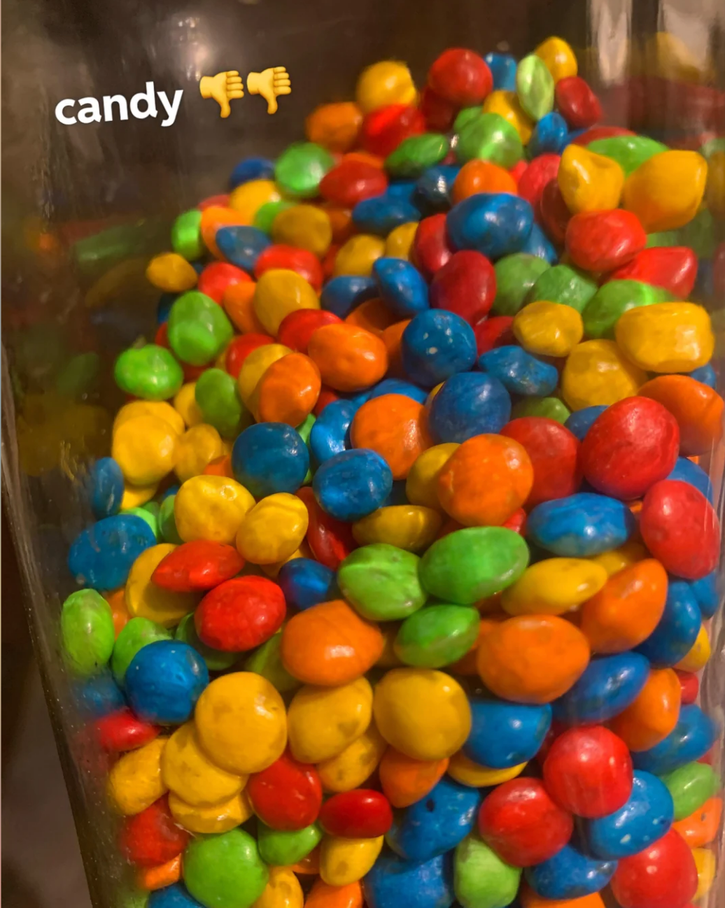 Candy jar filled with round, colorful candy; text reads "candy" with thumbs down emoji