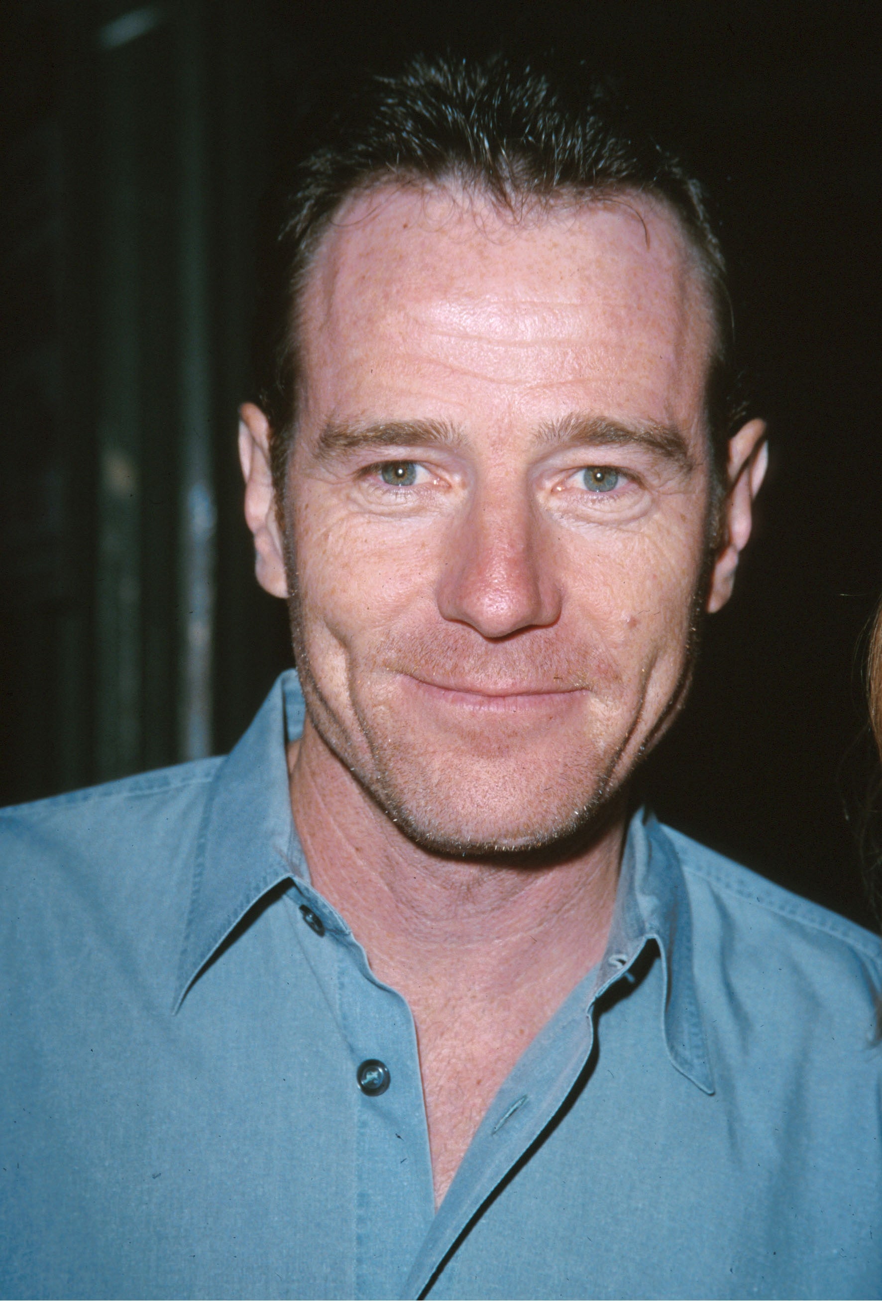 Bryan Cranston in a casual button-up shirt, smiling