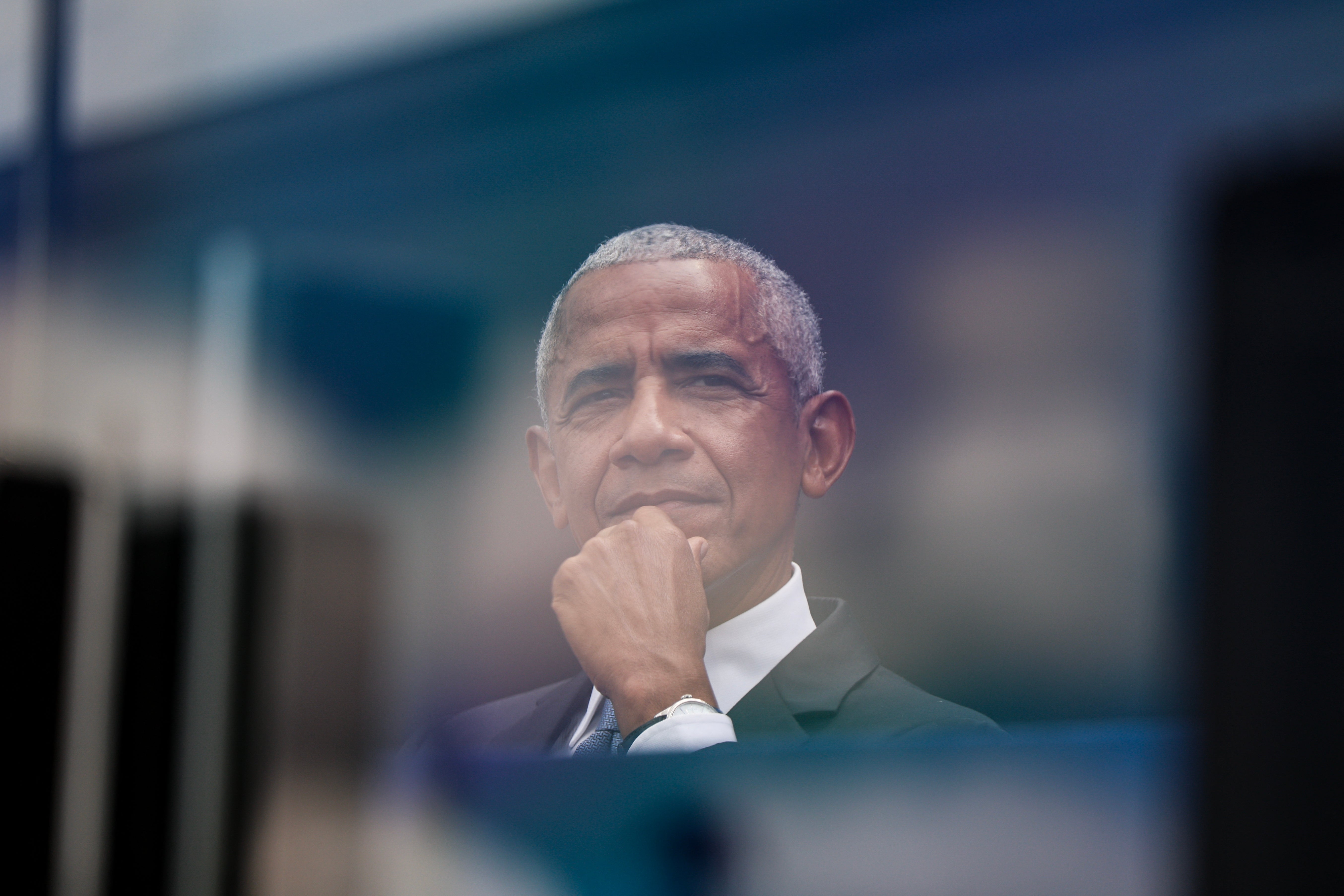 A idiosyncratic   successful  a suit   appears thoughtful, looking into the region  done  glass, with their manus  resting connected  their chin