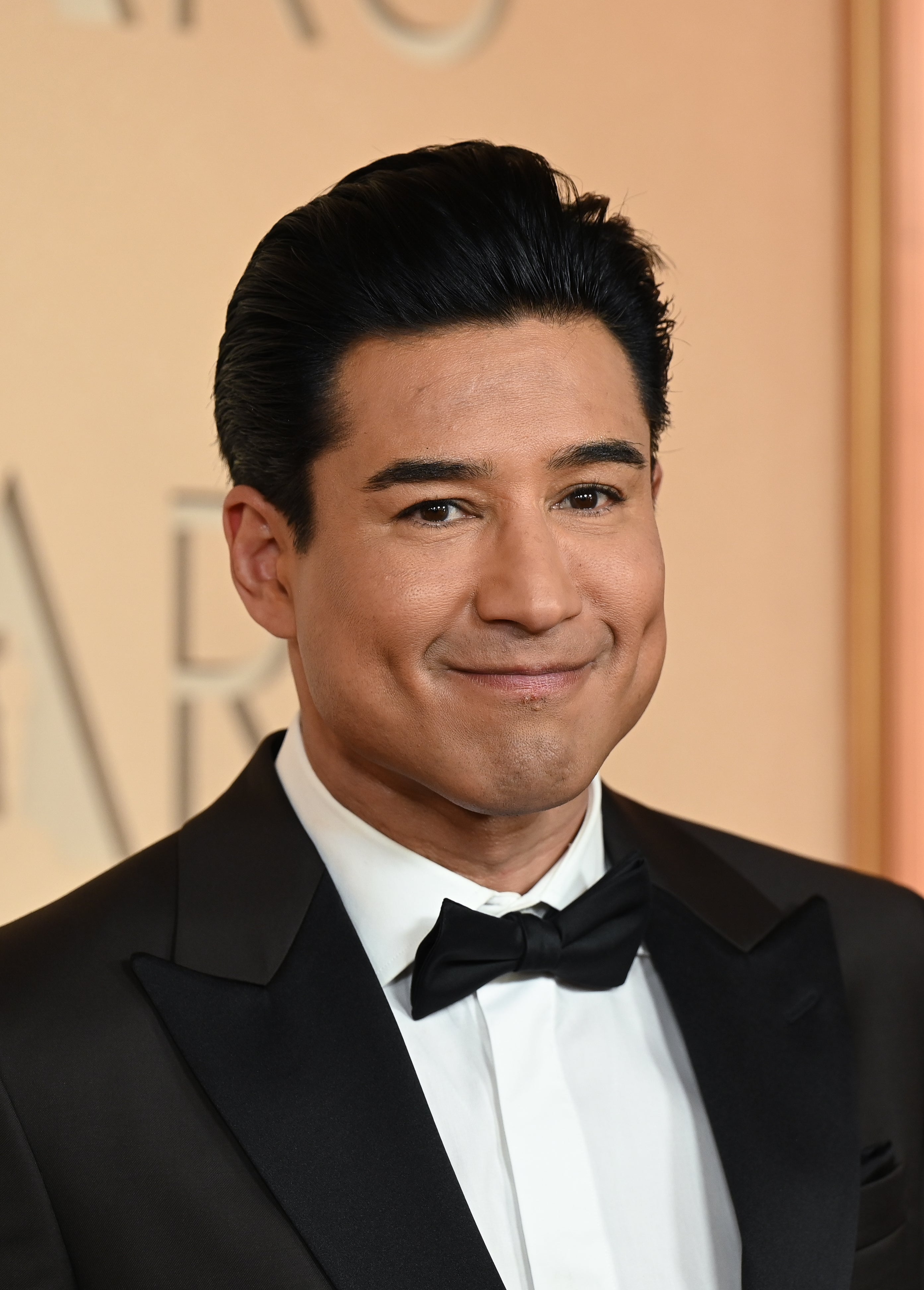 Mario Lopez i smoking med sløyfe ved en formell begivenhet, smilende til kameraet