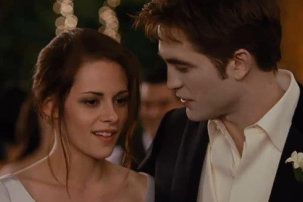 A couple looking at each other, dressed in formal evening attire at a festive event