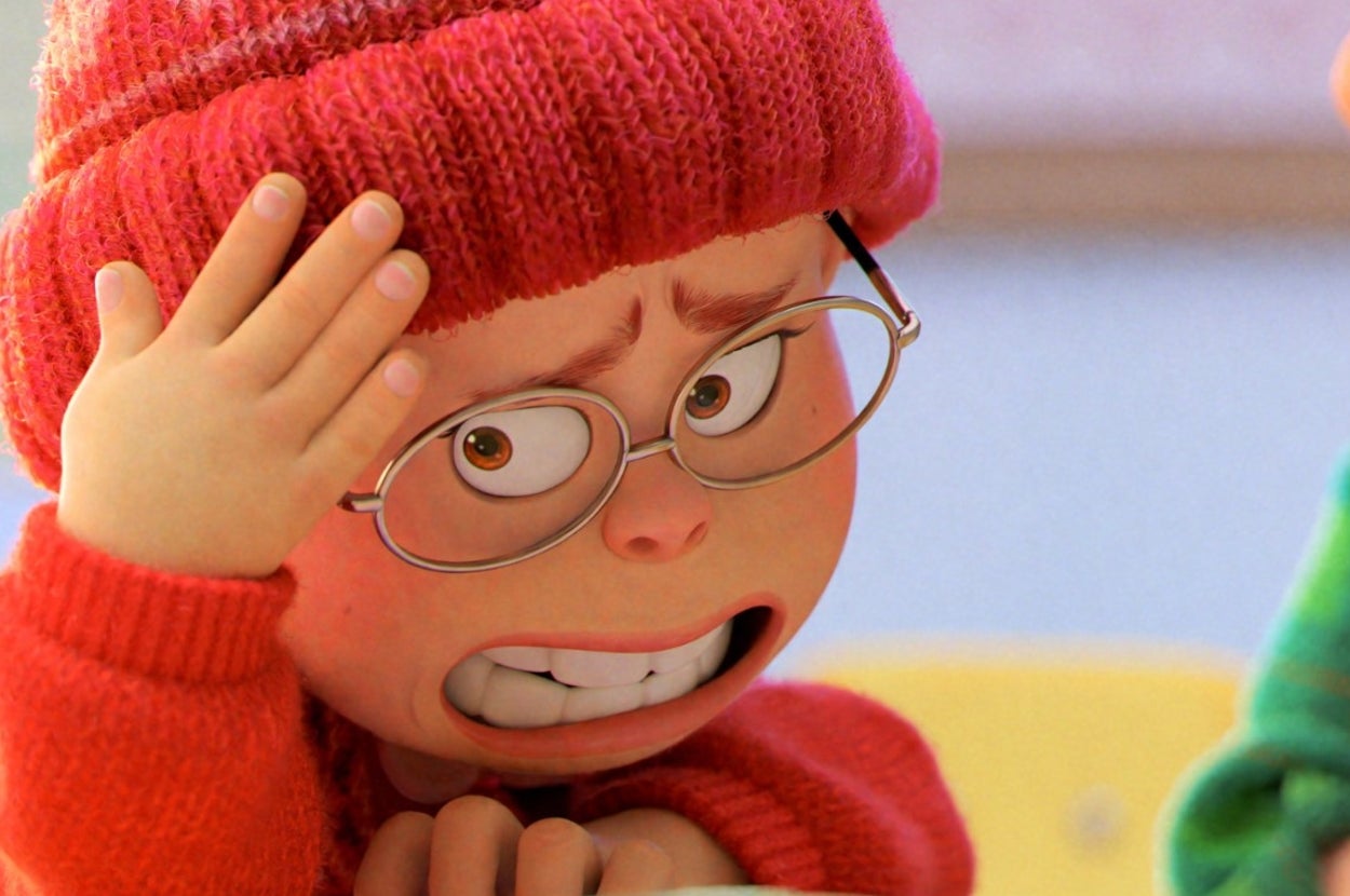Animated character with red hat and glasses looking stressed at school desk, sitting beside another character in green with a surprised expression