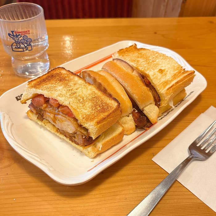コメダ珈琲店の「タンドリーチキンホットサンド」。フォークとナプキンが添えられている。