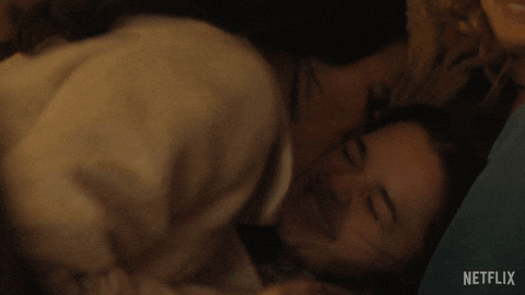 Two people embracing closely, sharing an intimate moment with warm expressions