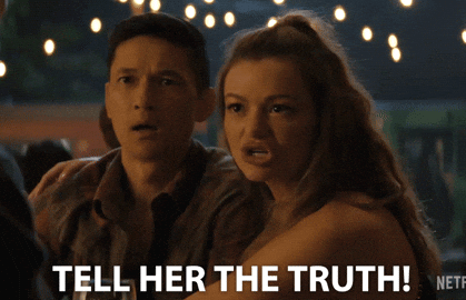 Two people with concerned expressions, one saying "Tell her the truth!" Lights hang overhead