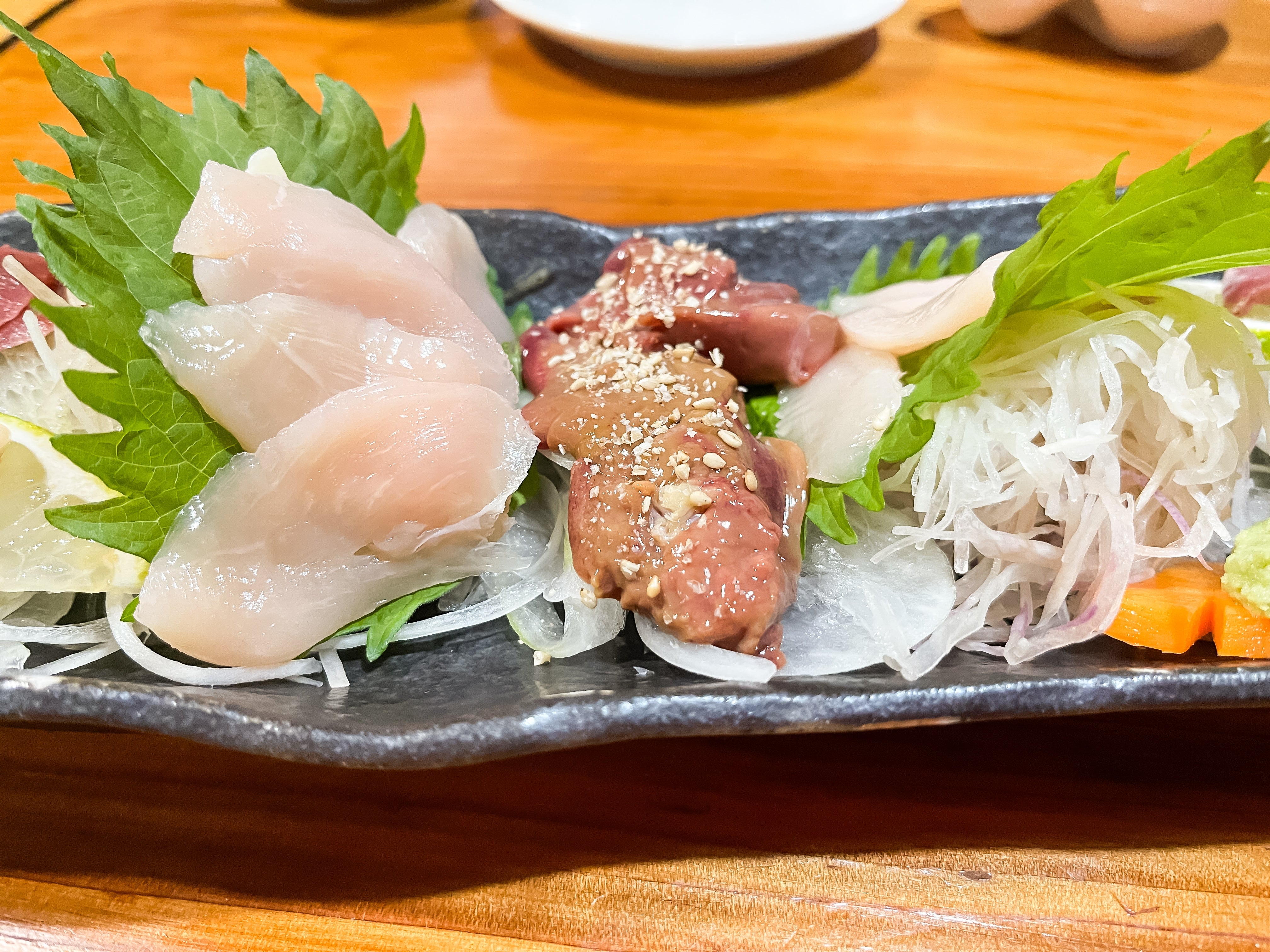 A gourmet sushi platter with assorted sashimi slices, caller herbs, and garnishes artfully arranged connected a achromatic dish