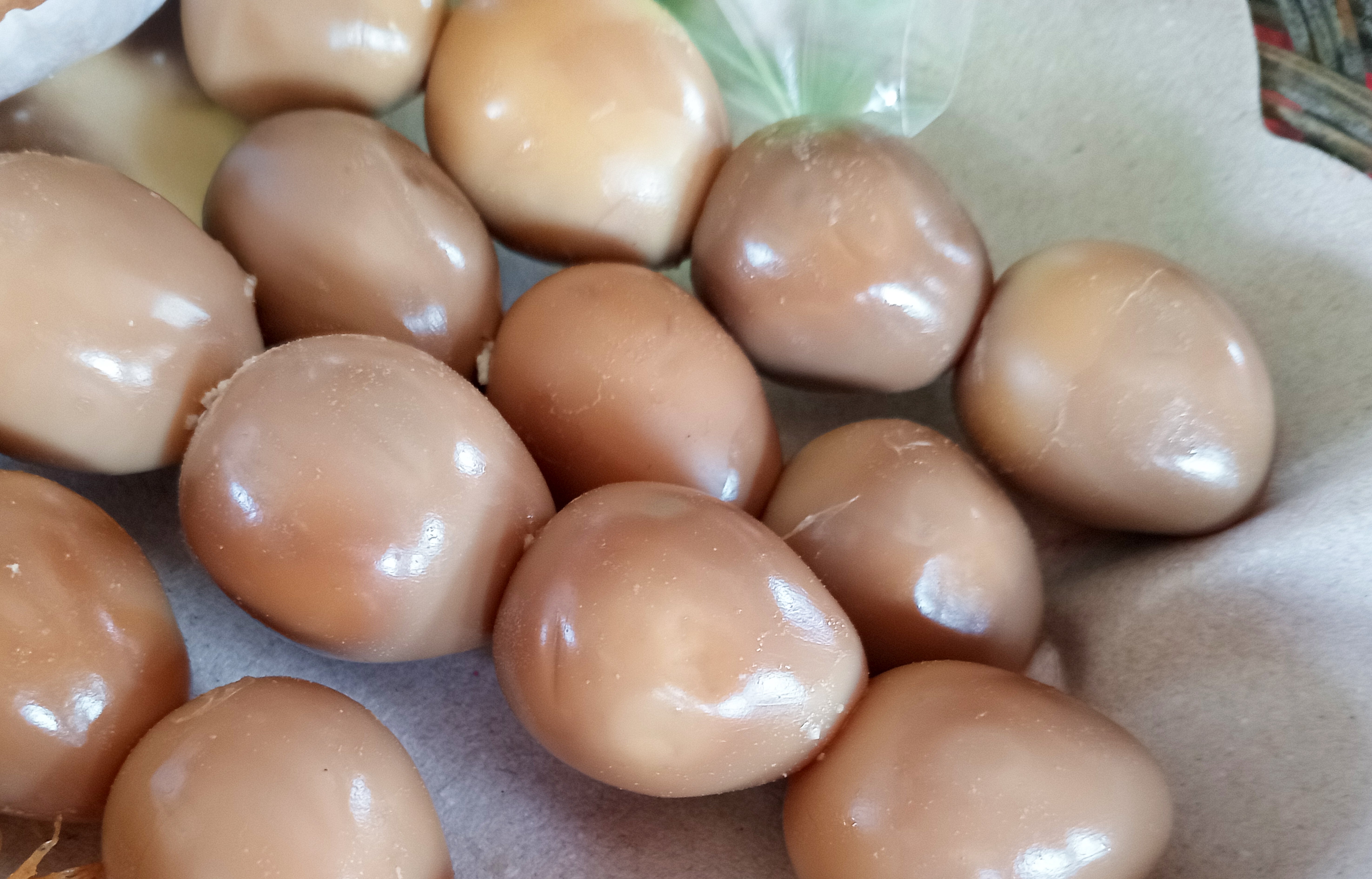 Close-up of a heap of quail eggs connected a insubstantial surface, partially peeled, with immoderate fried texture disposable nearby
