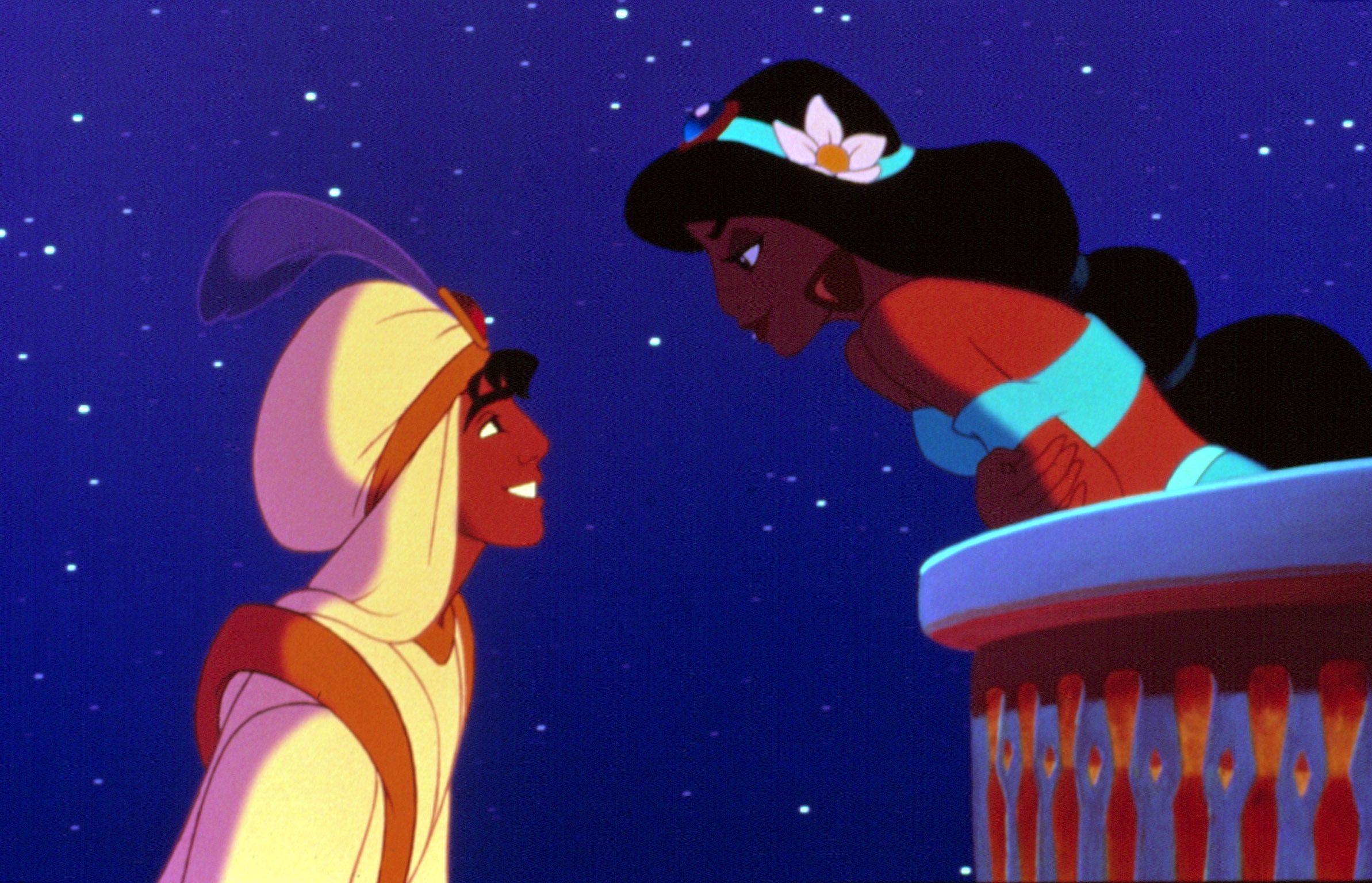 Aladdin and Jasmine share a romantic moment under the night sky, with Jasmine leaning on a balcony and Aladdin wearing his prince outfit