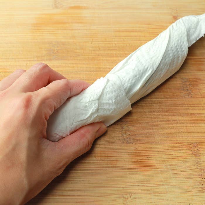 丸めたキッチンペーパーを持つ手。