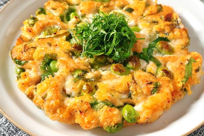 お皿に盛られたネギとエンドウを使ったお好み焼き風料理。中央には大葉がのっています。