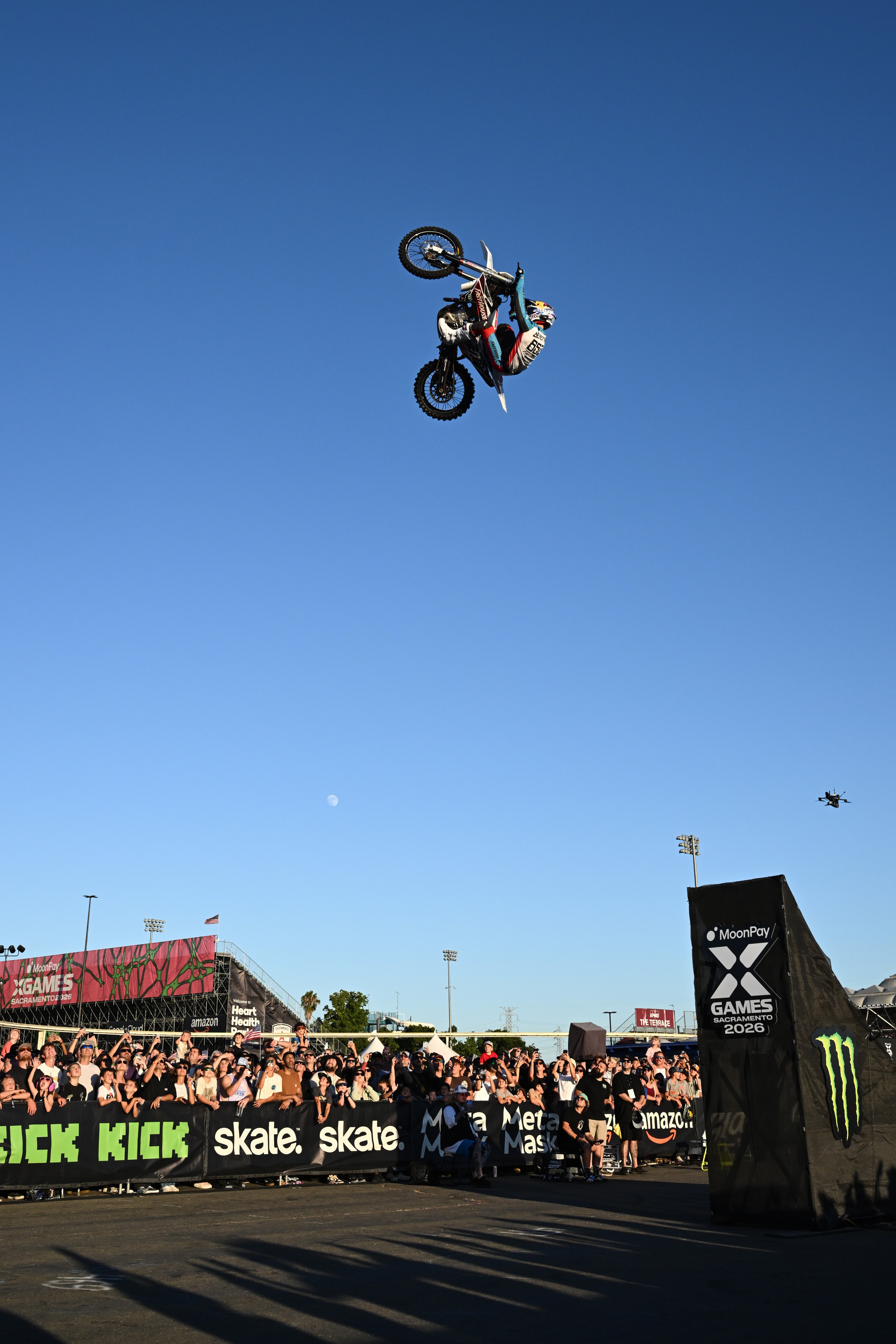 Motorcyclist performs a high-flying stunt supra  a ample  outdoor assemblage  astatine  a sports event