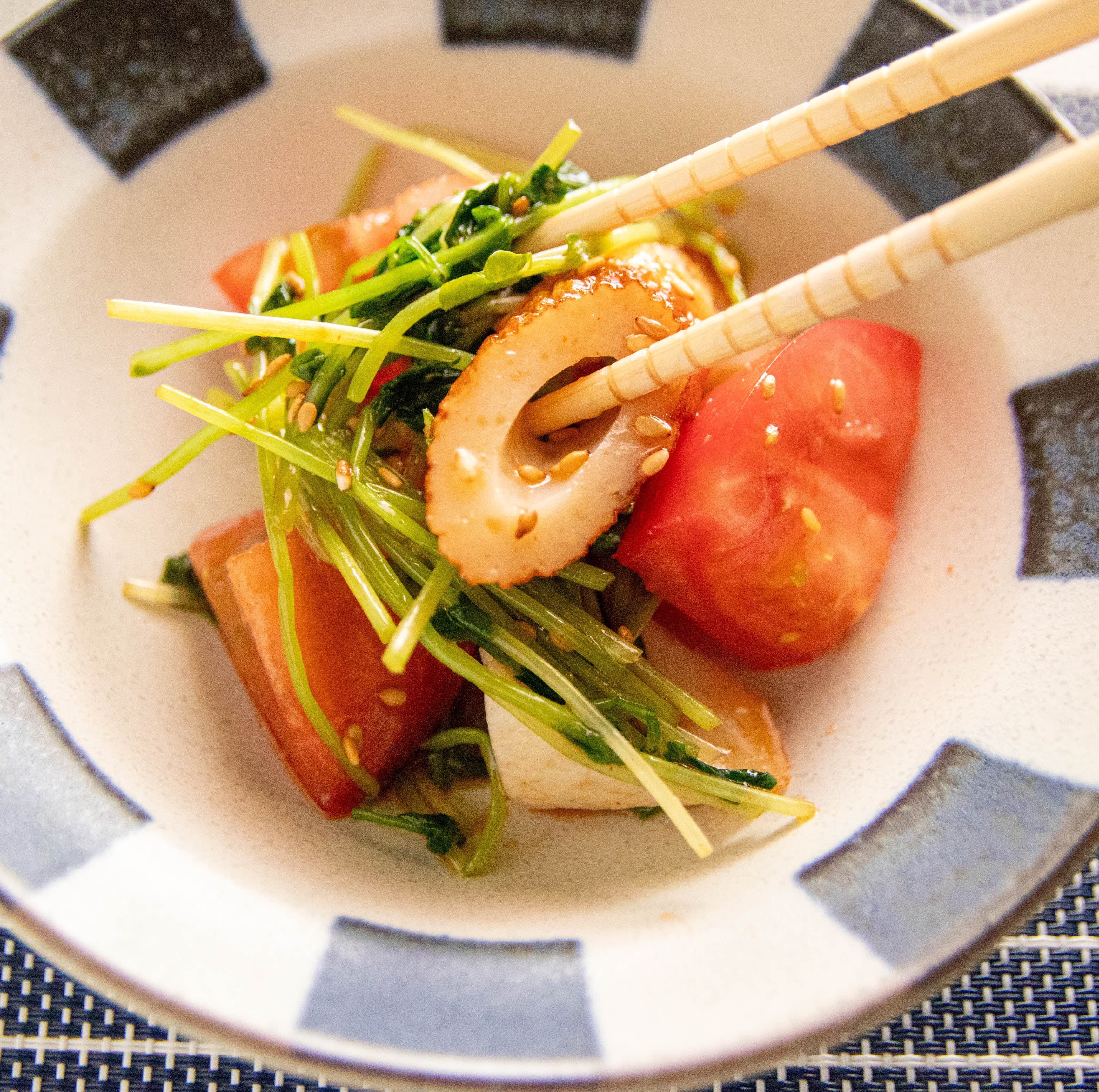 器にこんもりと盛り付けられた、ツヤのあるトマトと豆苗のピリ辛ちくわ和え。