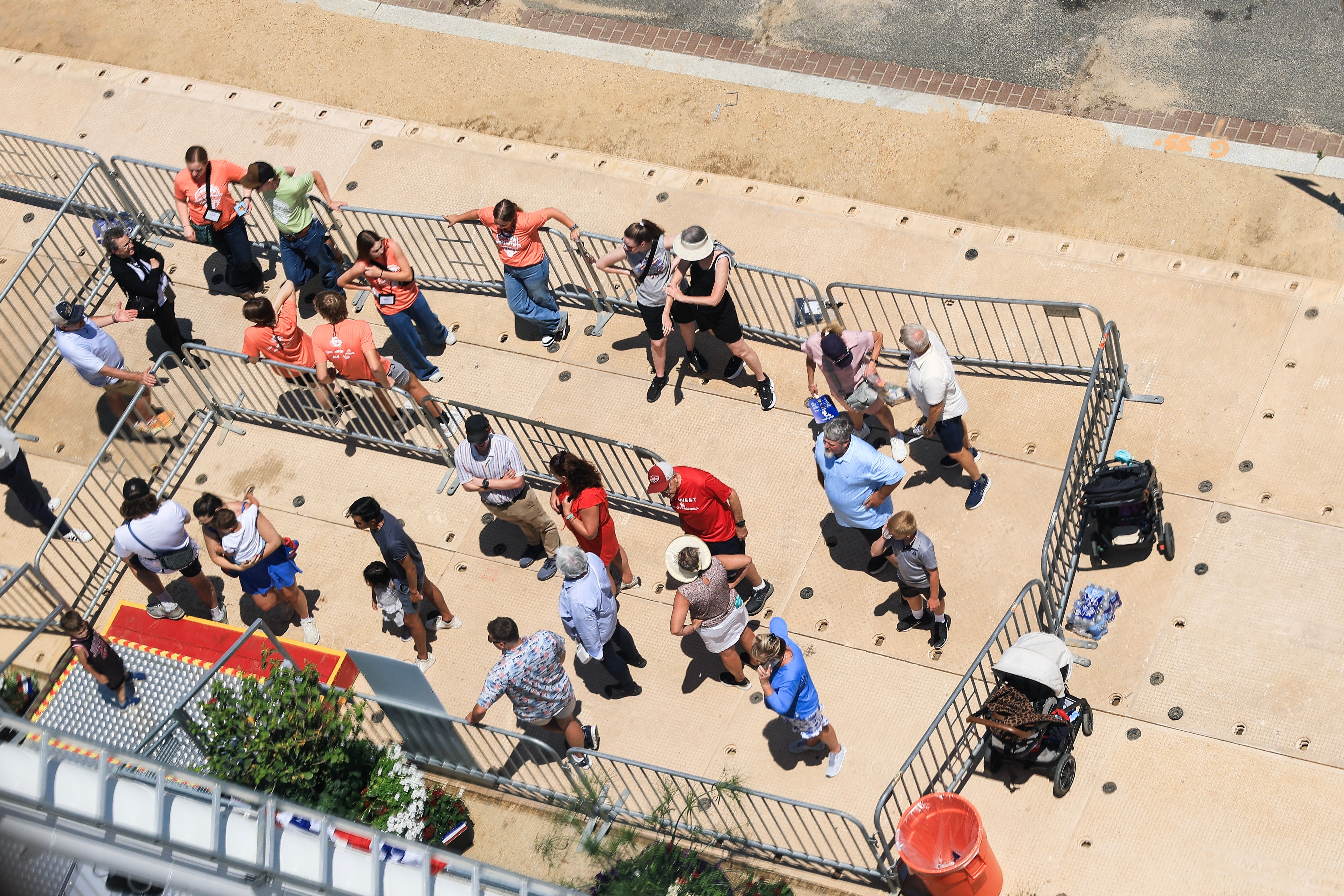 Aerial presumption of radical lasting successful a zigzag queue, immoderate wearing prima hats and casual clothing, extracurricular a fenced area