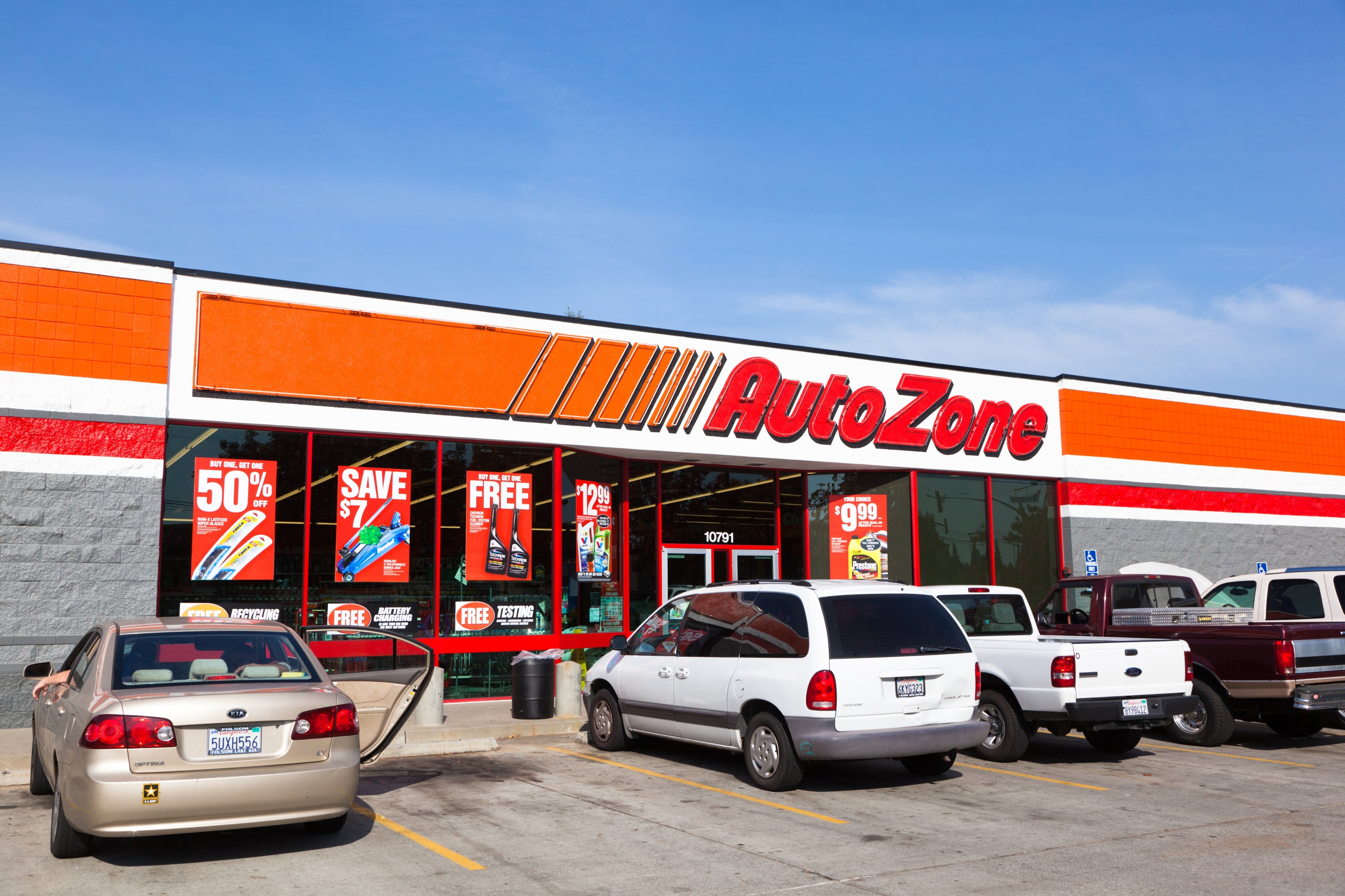 Storefront of an AutoZone with respective cars parked outside. Sale signs are disposable successful the windows