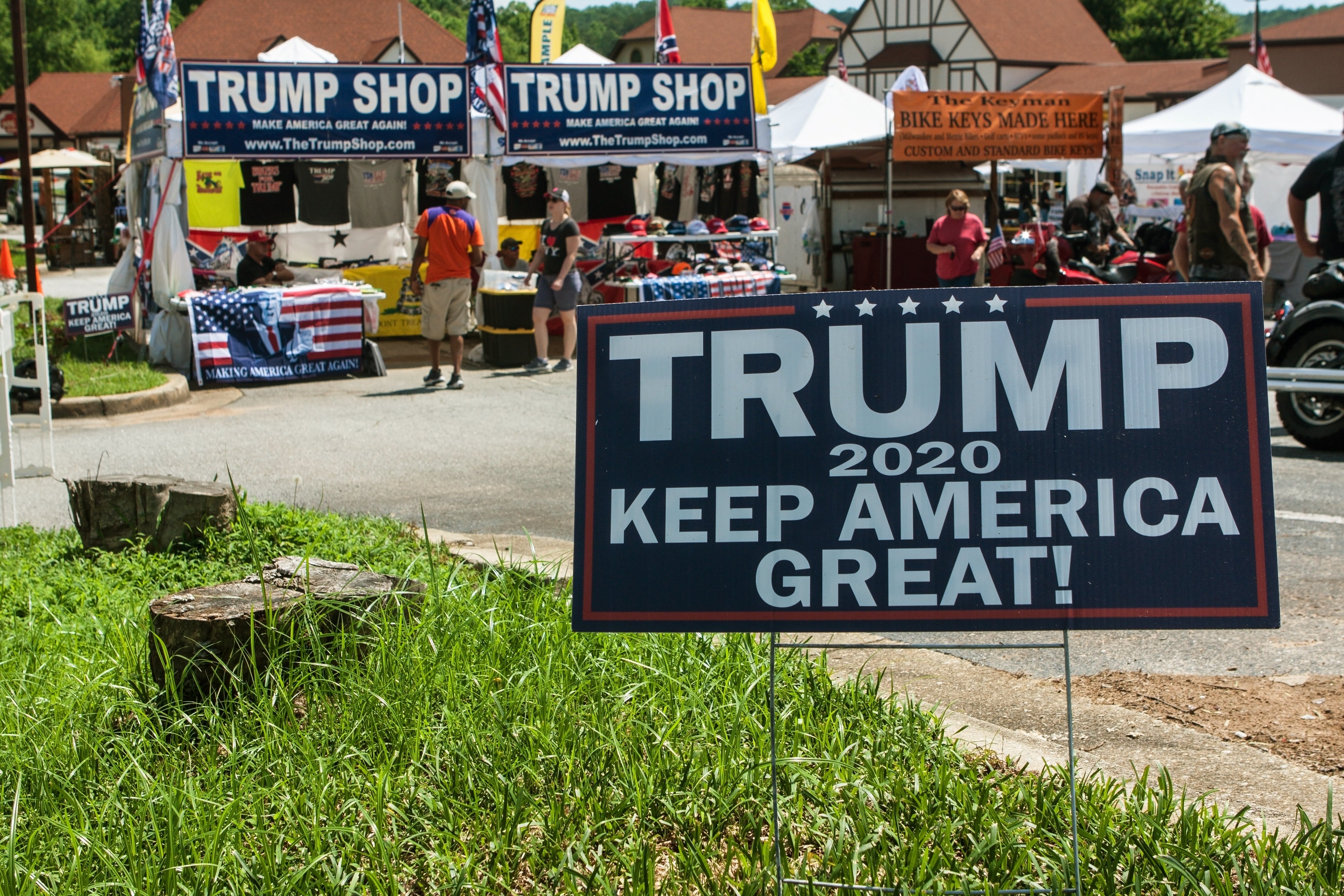 Outdoor vendor stands selling Trump 2020 merchandise, with a salient  motion   speechmaking  "Trump 2020 Keep America Great!" successful  the foreground