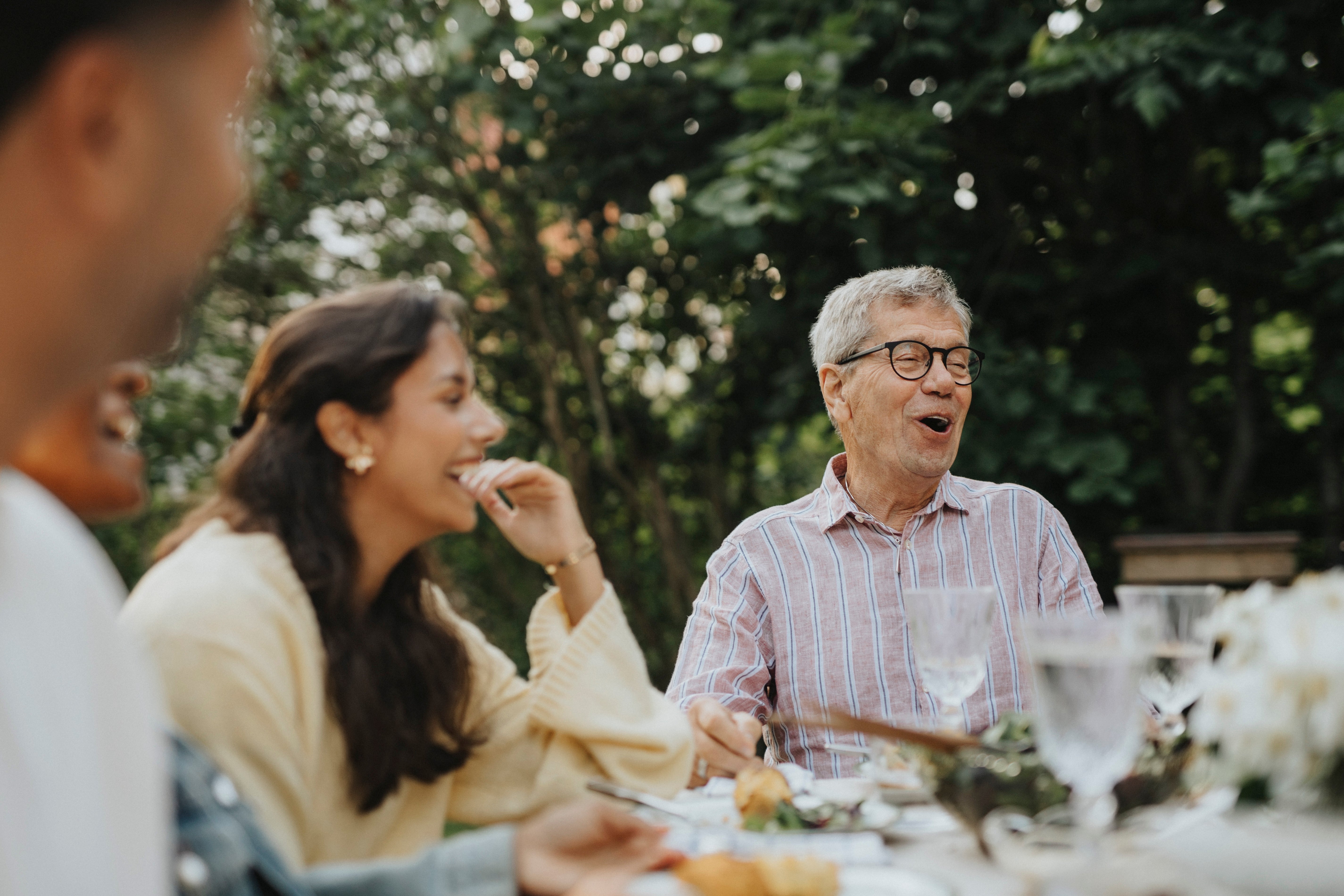 People laughing and conversing astir   an outdoor eating  table