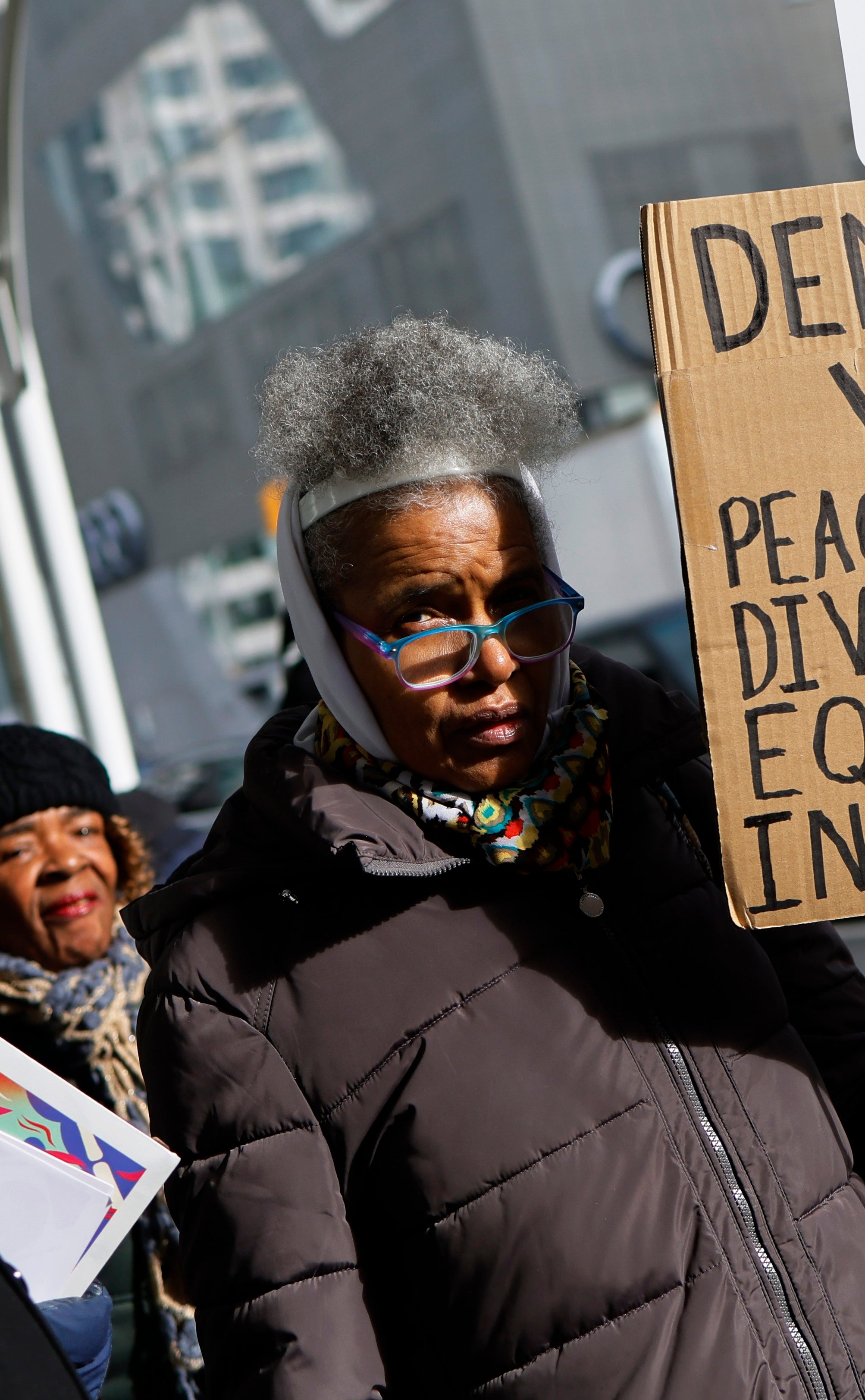 A idiosyncratic   holds a motion   advocating for democracy, voting, and values similar  peace, diversity, equity, and inclusion during a thoroughfare  gathering